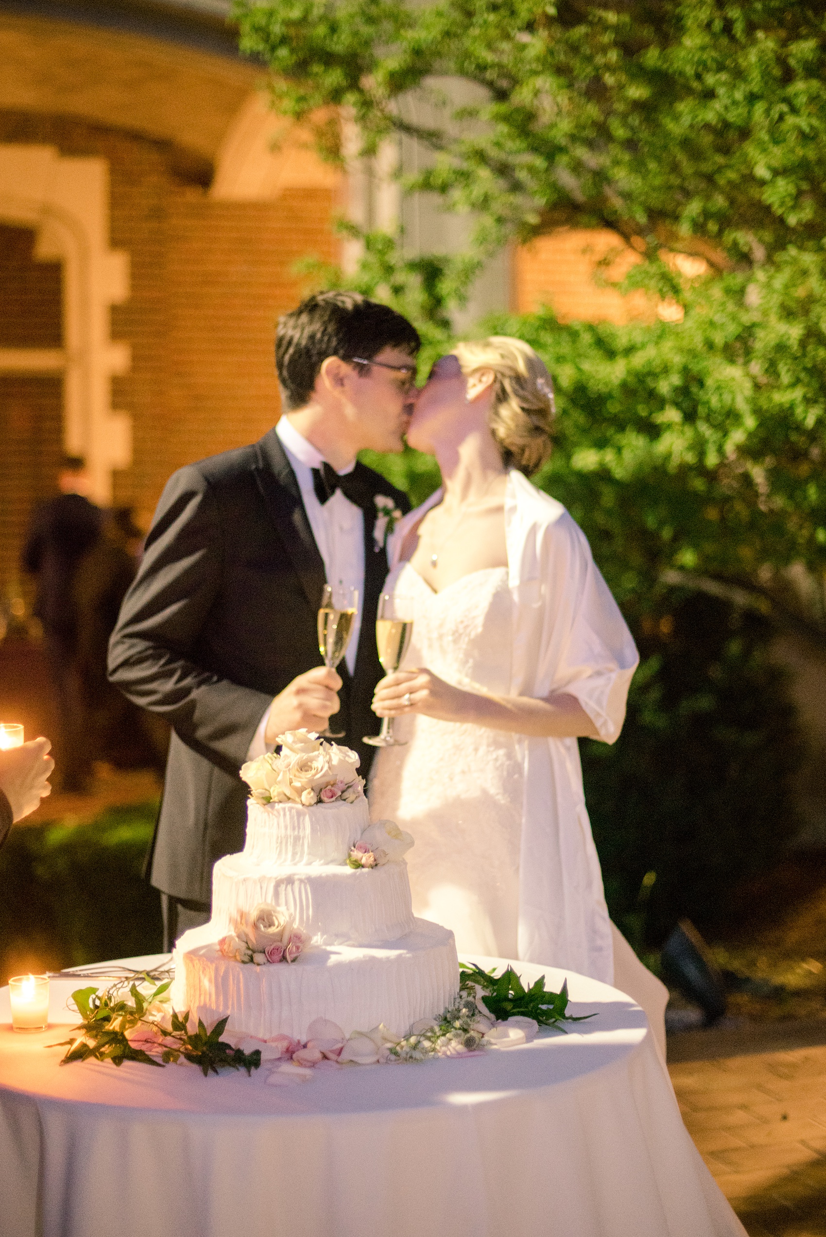 Waveny House wedding photos in Connecticut by Mikkel Paige Photography. Night picture of the bride and groom cutting the cake.