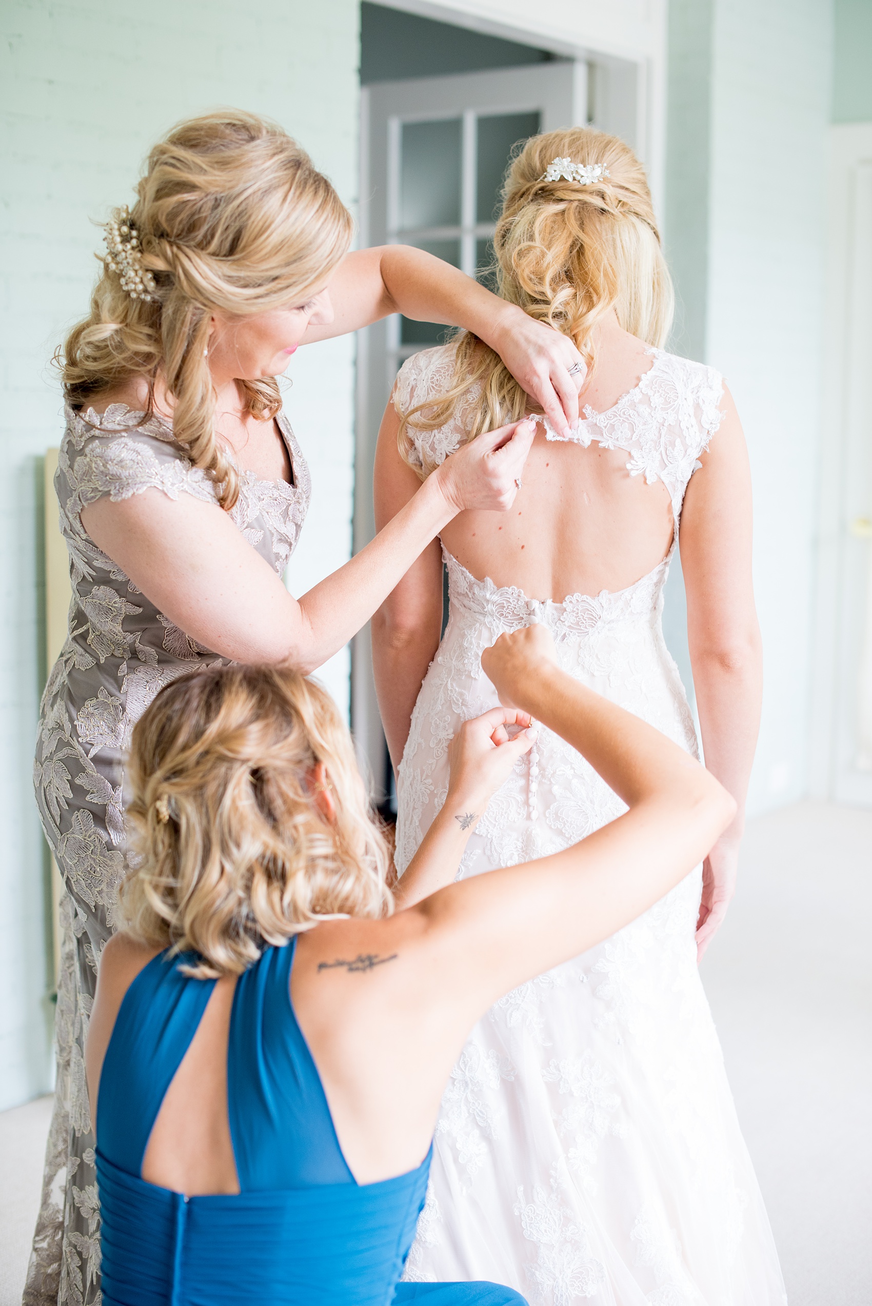 Mikkel Paige Photography photos from getting ready photos in Durham, North Carolina. Picture of the bride getting ready with her mother and sister, Maid of Honor, in a suite in King's Daughters Inn.