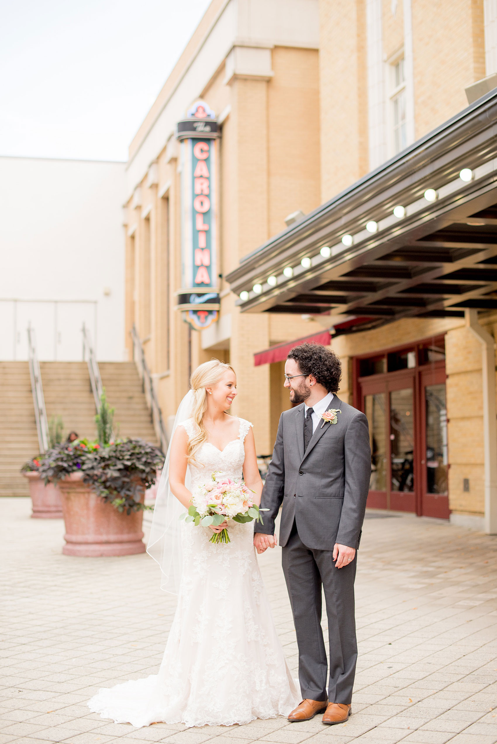 Mikkel Paige Photography photos from a wedding in Durham, North Carolina. Picture of the bride and groom in front of the Carolina sign at a downtown theater.