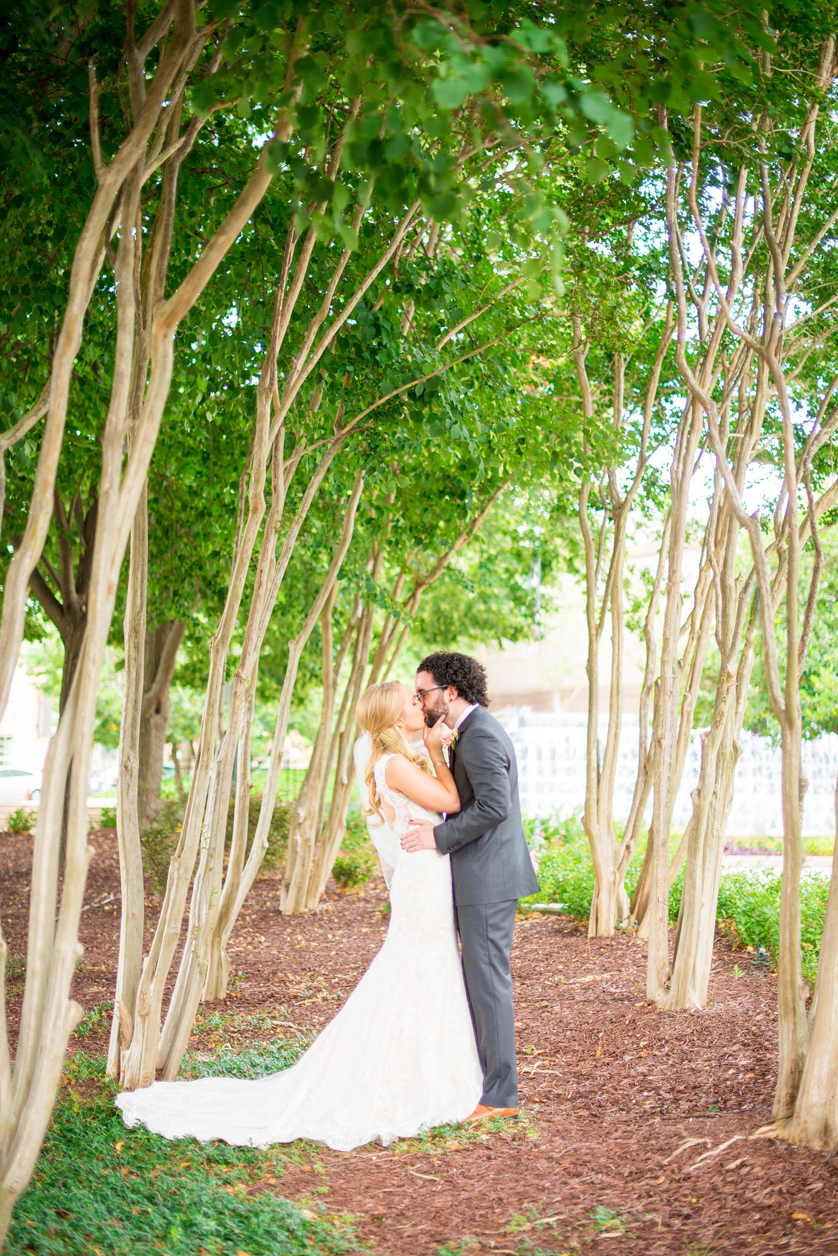 Mikkel Paige Photography photos from a wedding in Durham, North Carolina. Picture of the bride and groom kissing amongst tall trees.