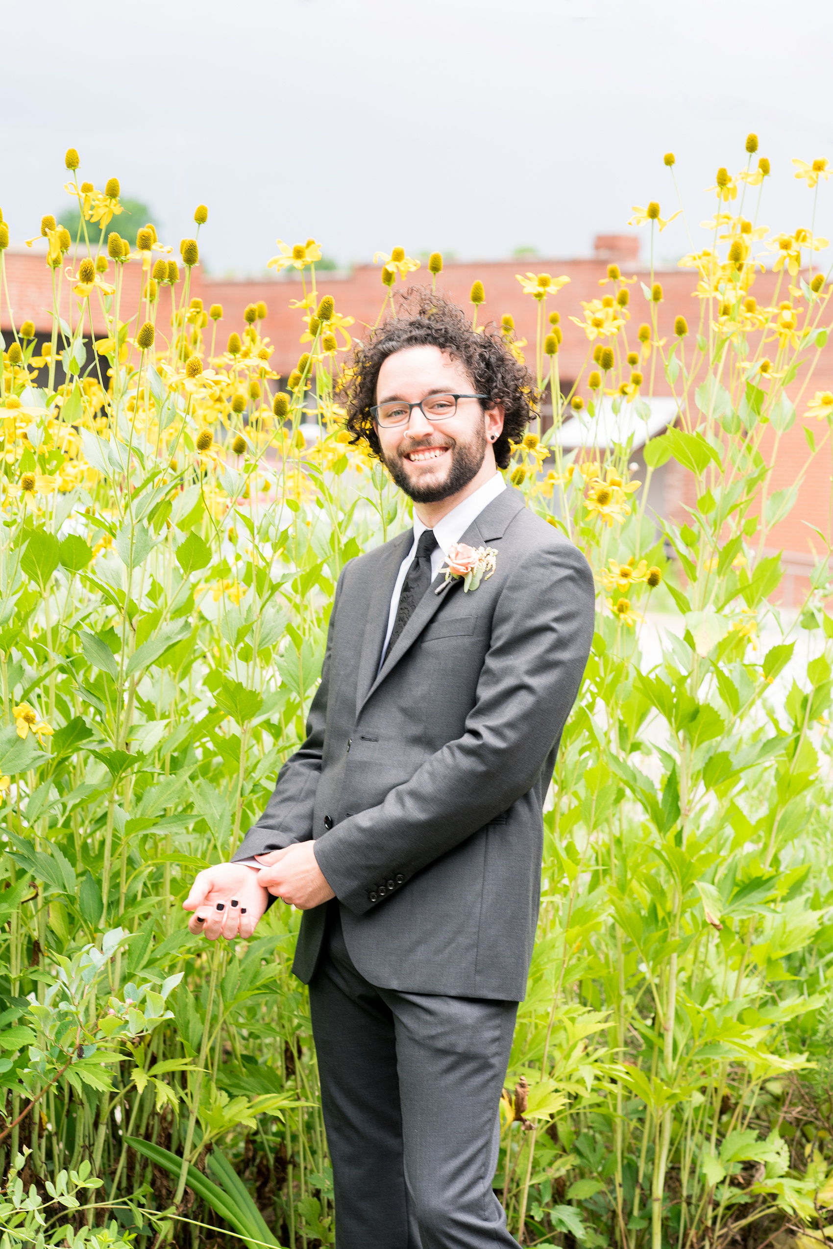 Mikkel Paige Photography photos from a wedding in Durham, North Carolina. Picture of the groom with yellow flowers behind him.