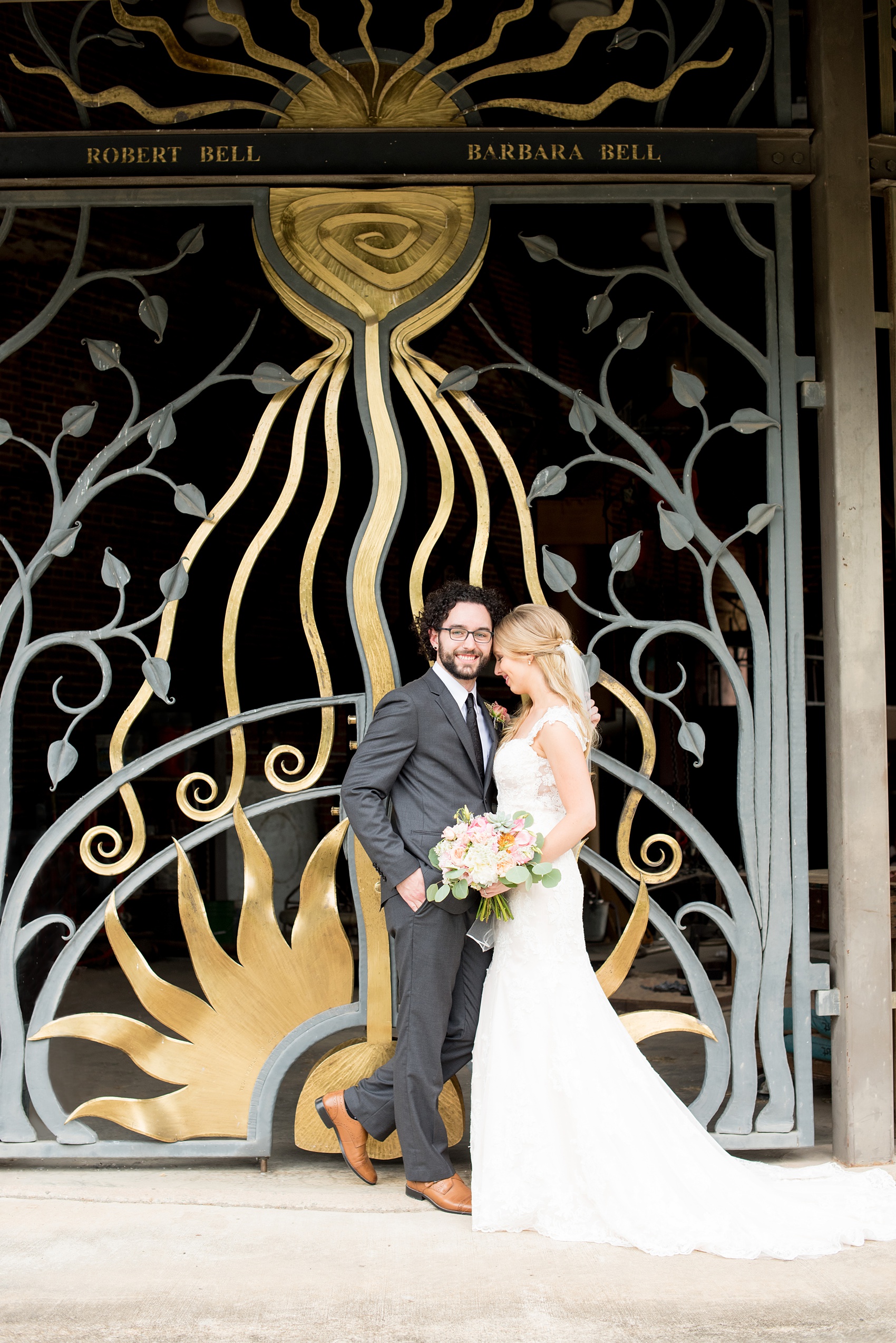 Mikkel Paige Photography photos from a wedding in Durham, North Carolina. Picture of the bride and groom in front of a black and gold gate.