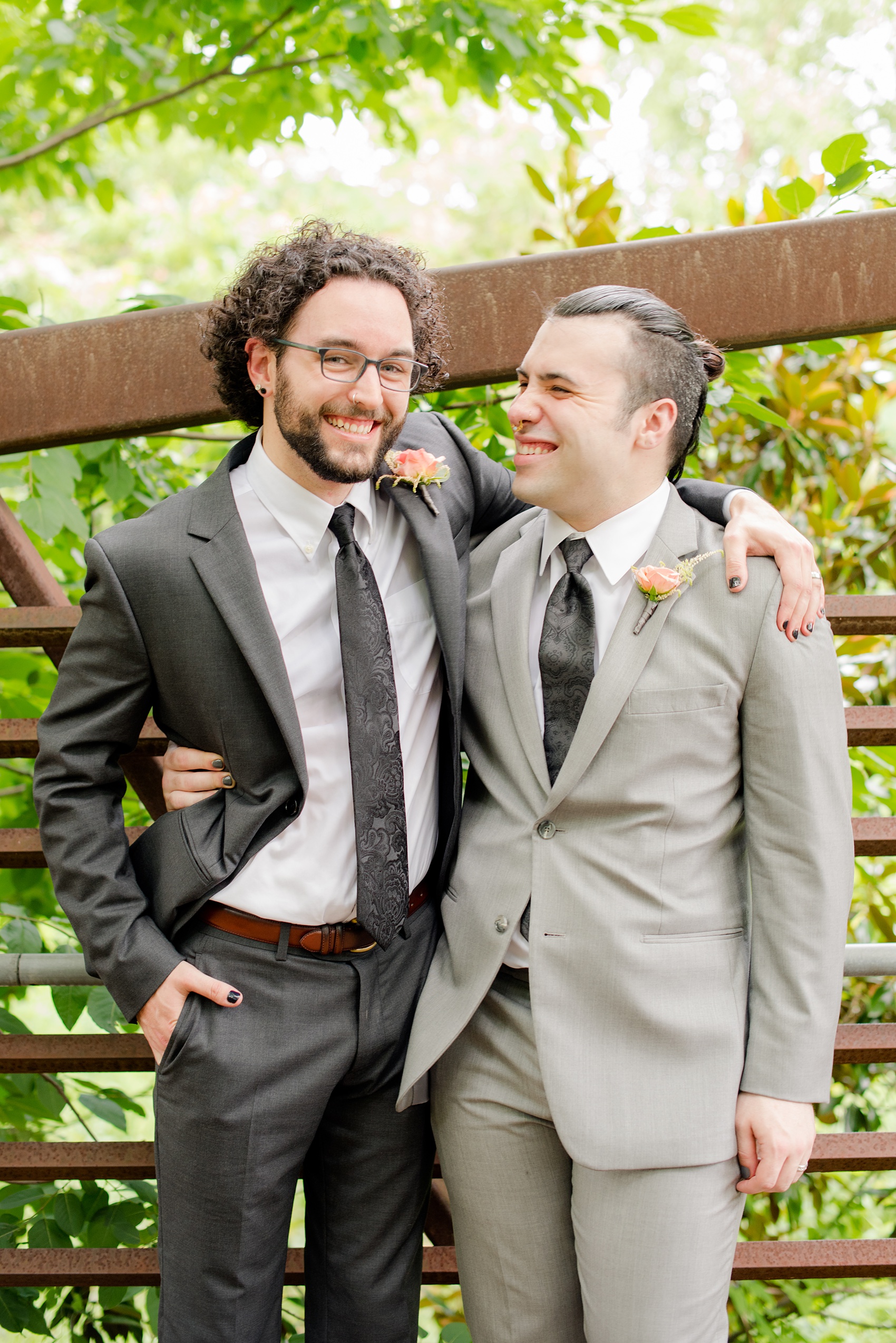 Mikkel Paige Photography photos from a wedding in Durham, North Carolina. Casual picture of the groom and his groomsman in grey suits on a rustic bridge downtown.