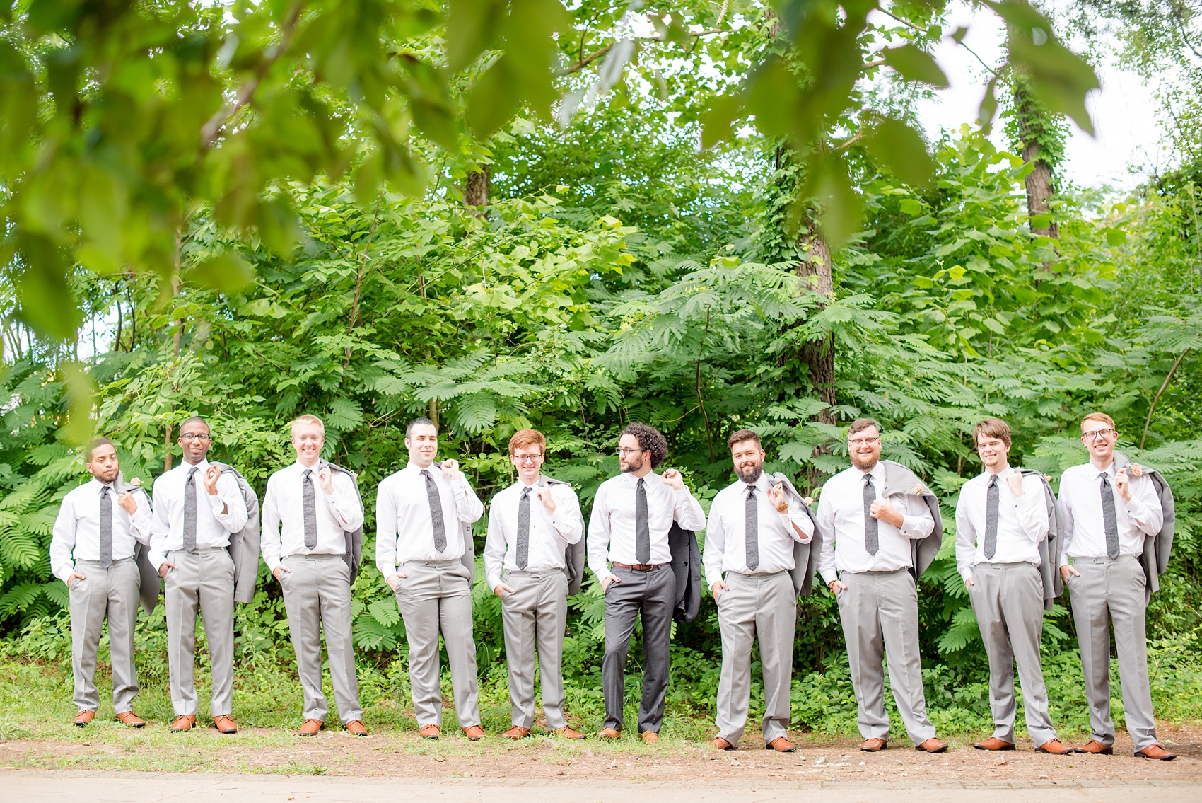 Mikkel Paige Photography photos from a wedding in Durham, North Carolina. Casual picture of the groomsmen holding their suit jackets in a downtown park.