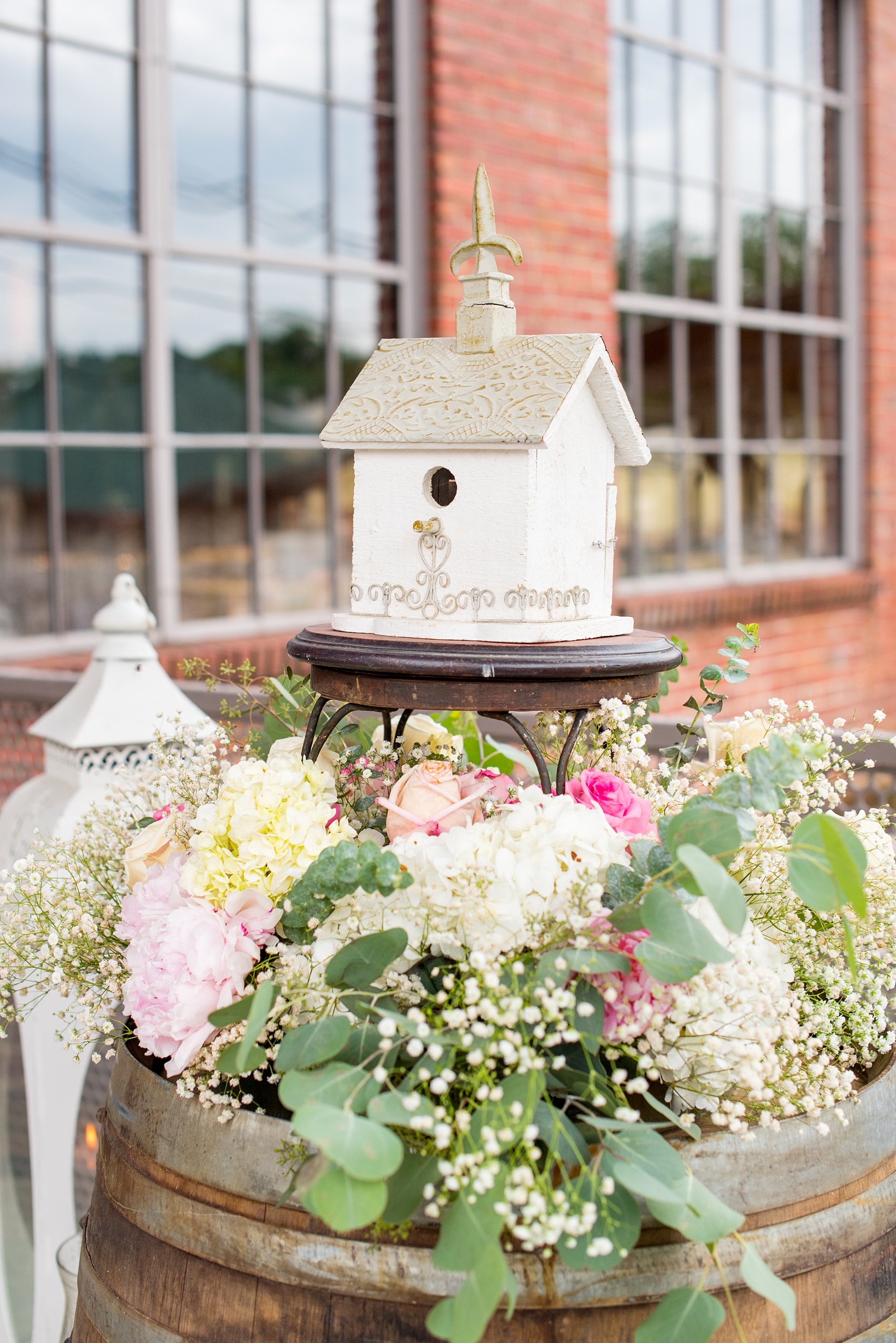 Mikkel Paige Photography photos from a wedding in Durham, North Carolina. Picture of the entrance to their wedding at The Rickhouse including flowers and a birdhouse.