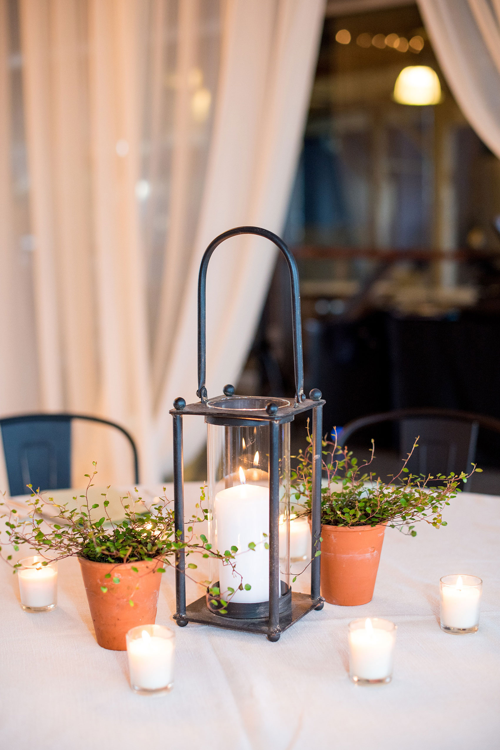 Mikkel Paige Photography photos from a wedding at The Rickhouse in Durham, North Carolina. Picture of the reception setup with flowers and rustic lantern centerpieces.