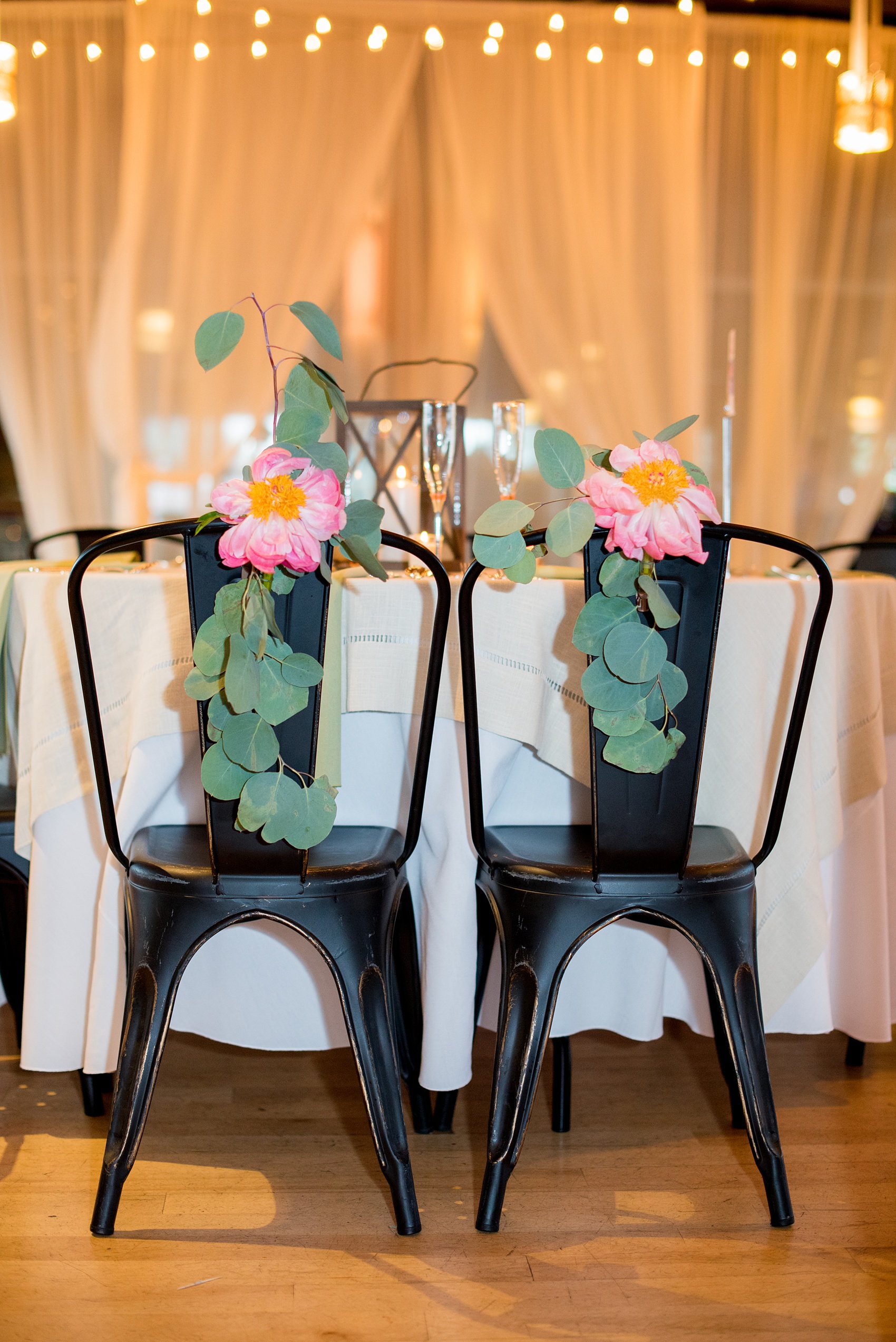 Mikkel Paige Photography photos from a wedding at The Rickhouse in Durham, North Carolina. Picture of the peony and eucalyptus chair decorations for the bride and groom.