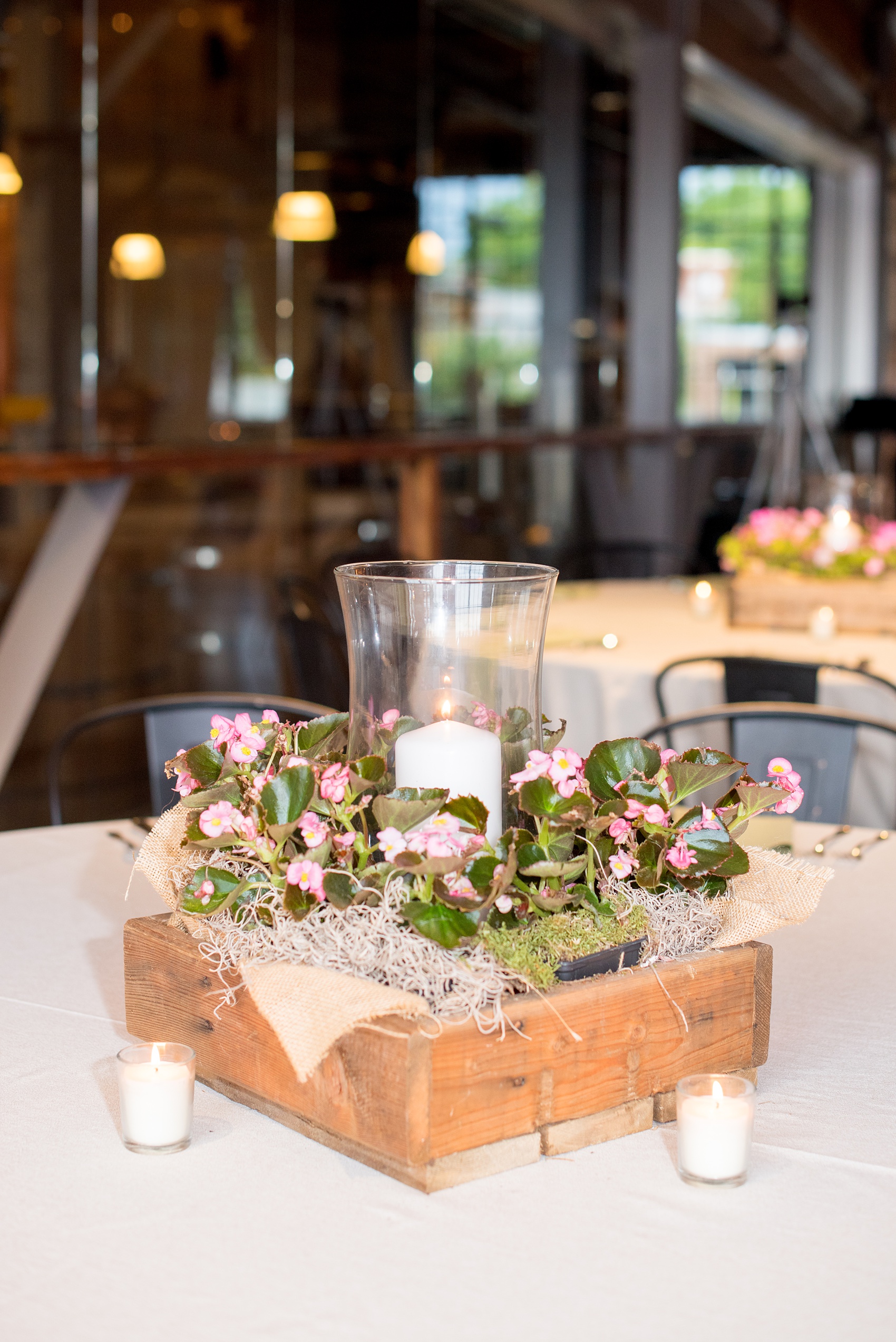 Mikkel Paige Photography photos from a wedding at The Rickhouse in Durham, North Carolina. Picture of the reception setup with flowers and rustic lantern centerpieces.