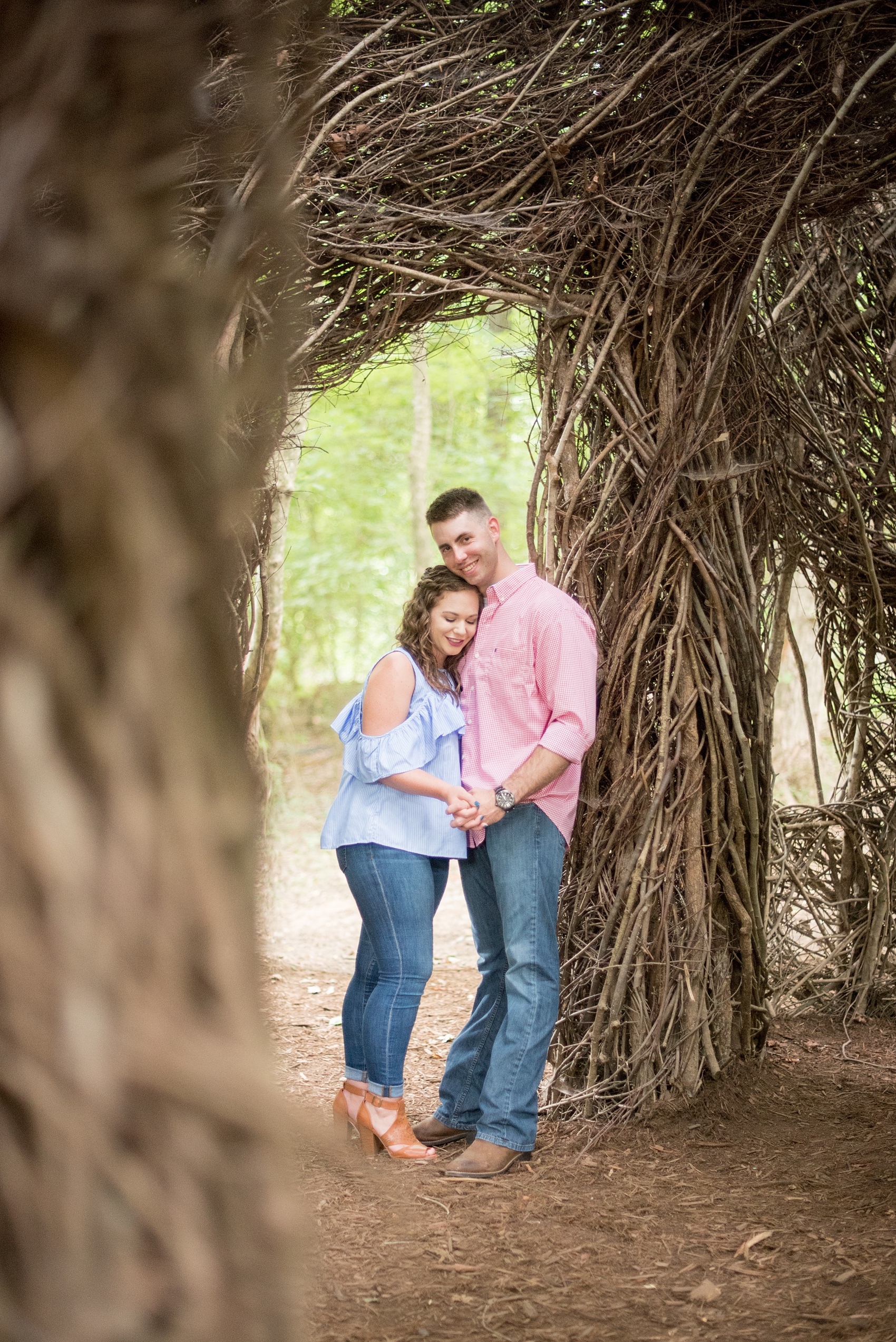 Mikkel Paige Photography photos of an engagement session at Eno Riverwalk in Hillsborough, North Carolina. Picture of bride and groom in a Stick Art sculpture created from branches.