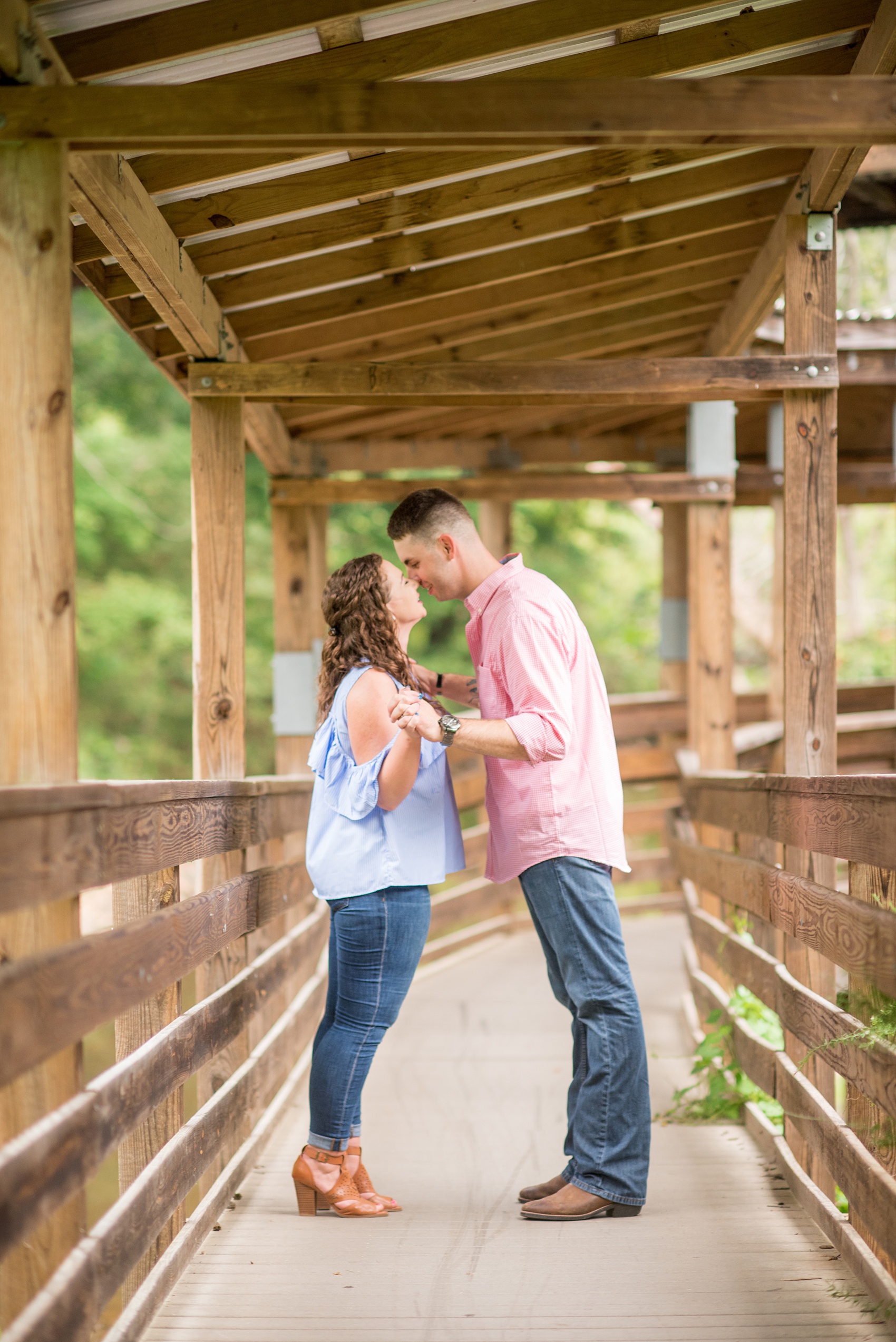 Mikkel Paige Photography photos of an engagement session at Eno Riverwalk in Hillsborough, North Carolina. Picture of bride and groom in a wooden tunnel.