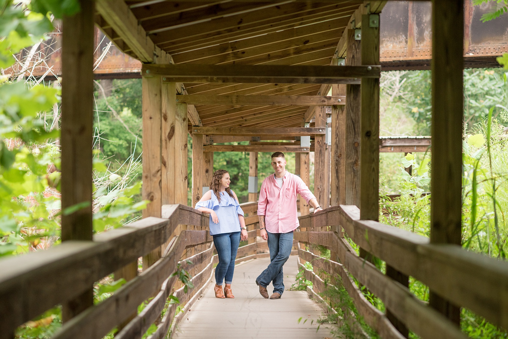 Mikkel Paige Photography photos of an engagement session at Eno Riverwalk in Hillsborough, North Carolina. Picture of bride and groom in a wooden tunnel.