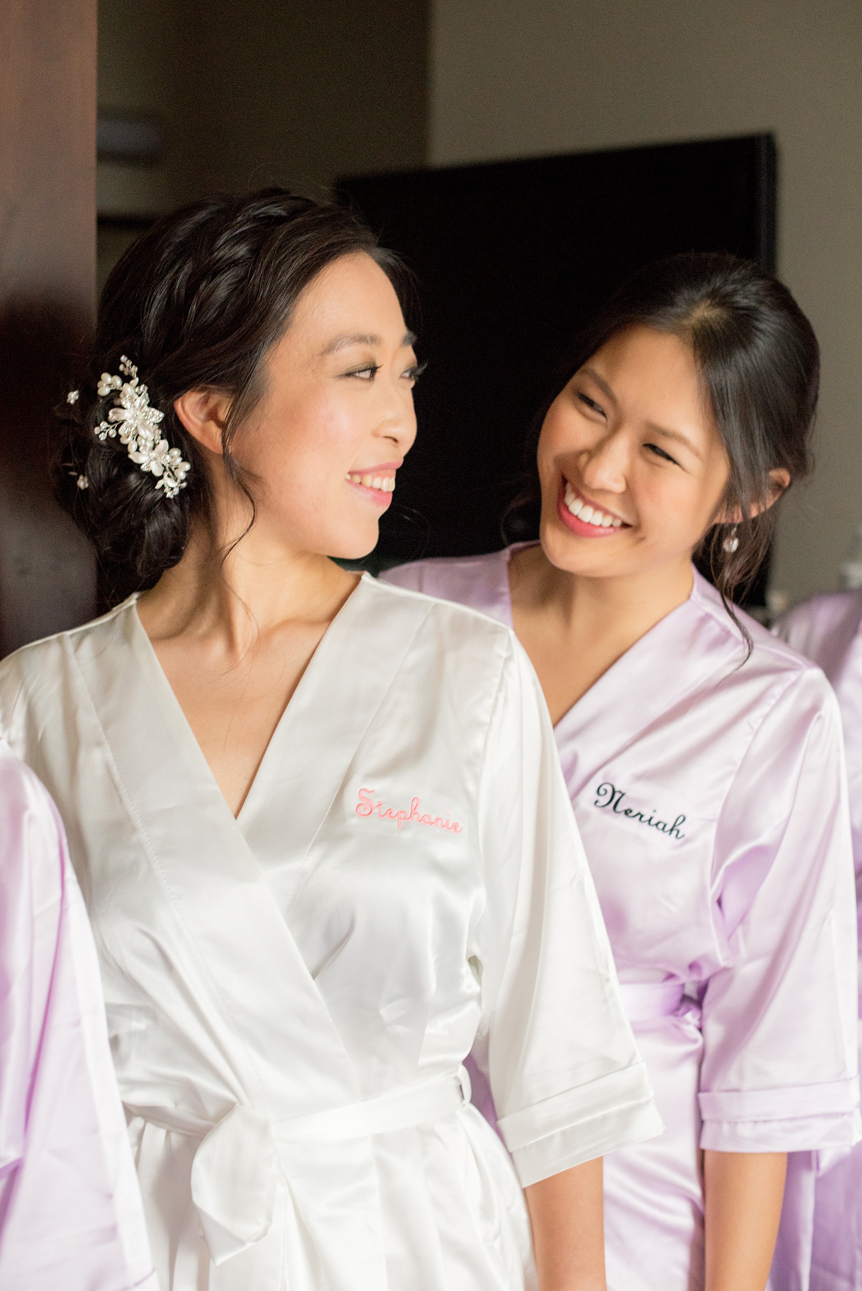 Mikkel Paige Photography pictures of a Westbury Manor wedding on Long Island. Detail photo of the bride getting ready in a monogrammed robe with her bridesmaids.