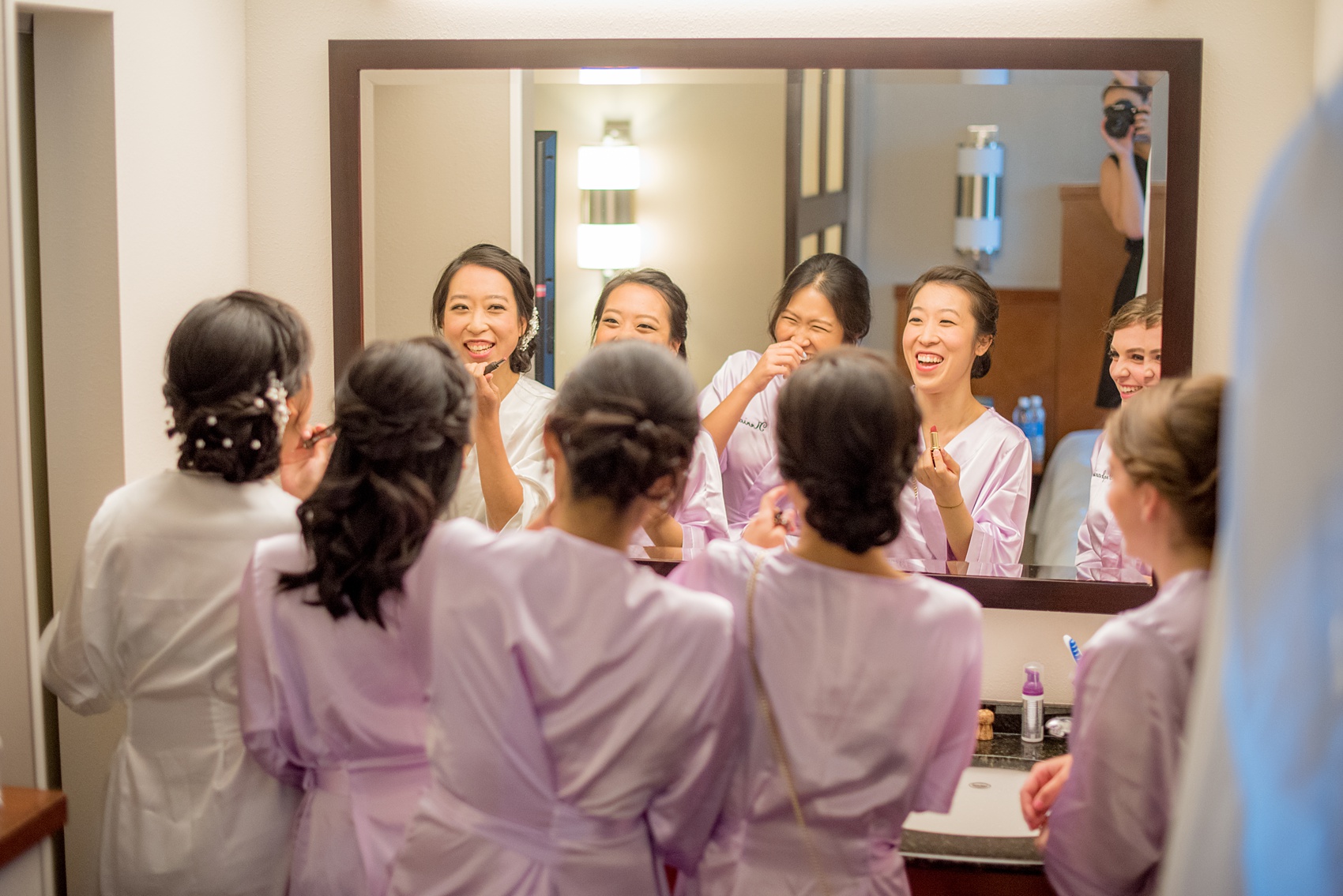 Mikkel Paige Photography pictures of a Westbury Manor wedding on Long Island. Detail photo of the bride getting ready in a monogrammed robe with her bridesmaids.