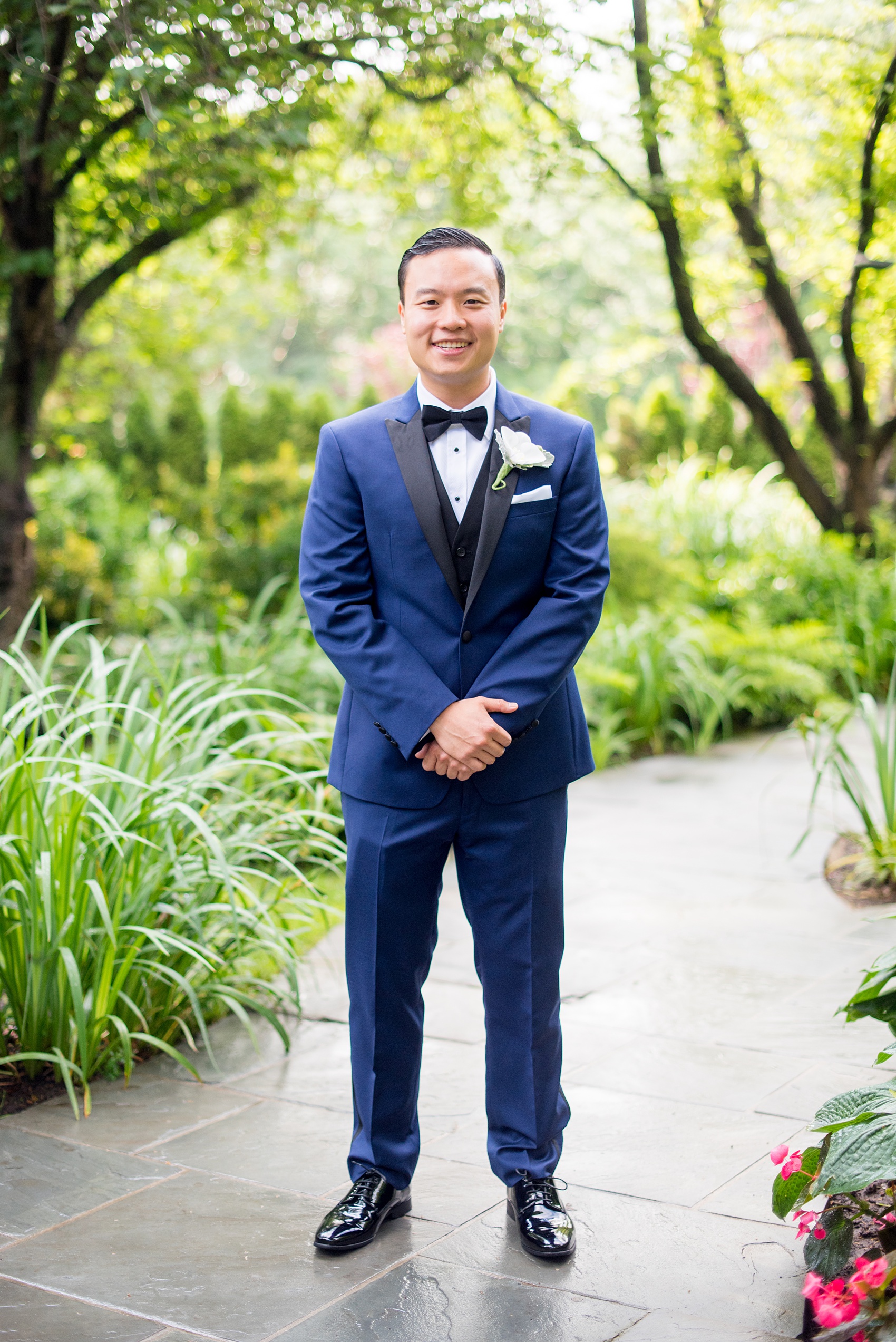 Mikkel Paige Photography pictures of a Westbury Manor wedding on Long Island. Photo of the groom in a blue suit with black lapel and bow tie.