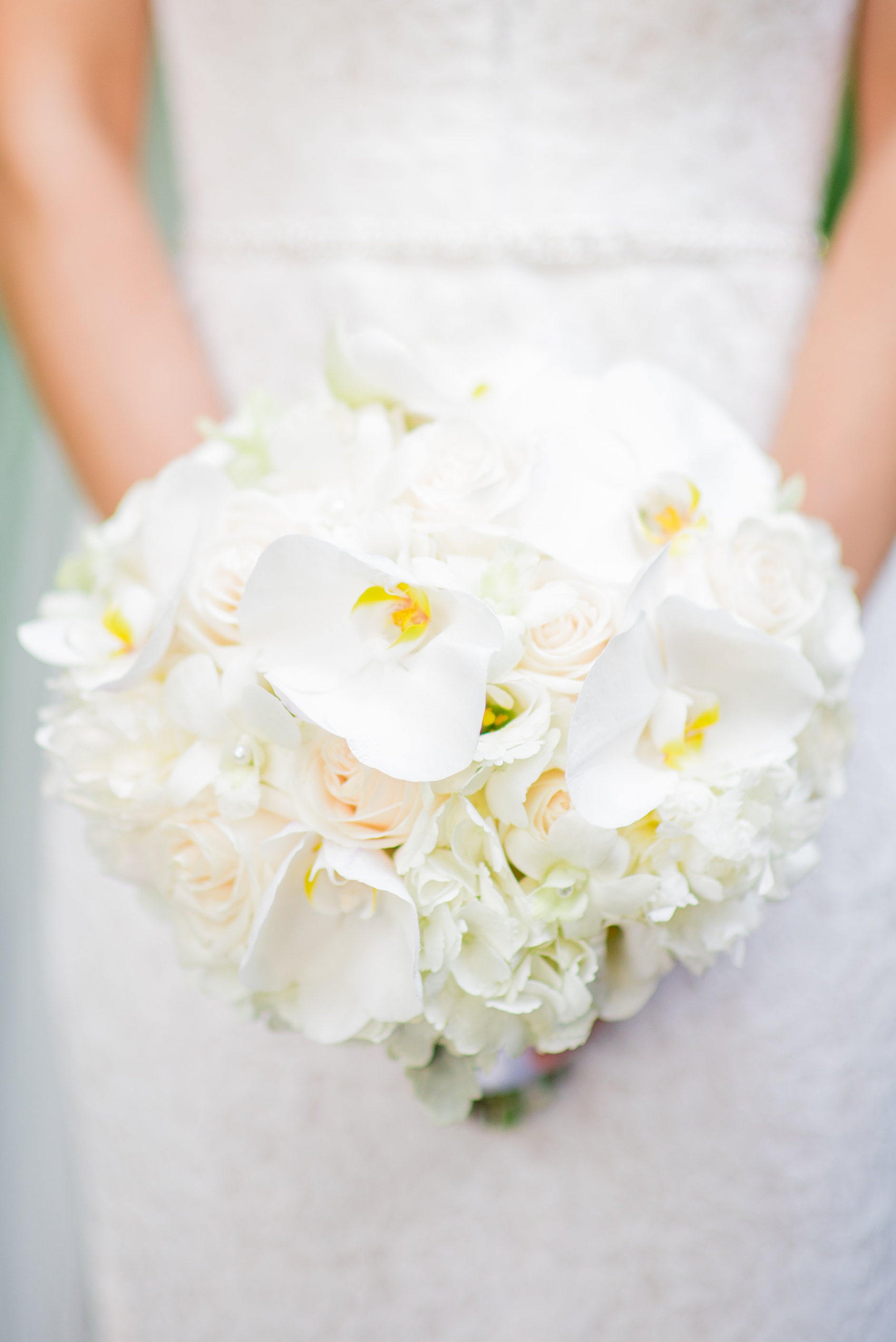 Mikkel Paige Photography pictures of a Westbury Manor wedding on Long Island. Detail photo of the bride's white orchid, hydrangea and rose bouquet.