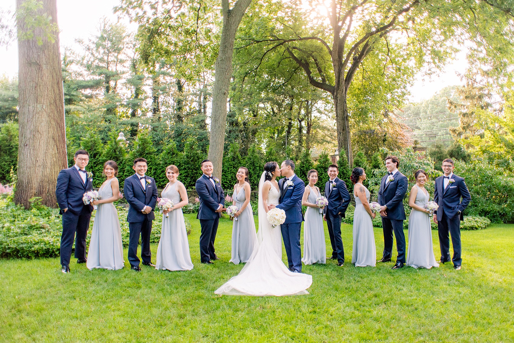 Mikkel Paige Photography pictures of a Westbury Manor wedding on Long Island. Photo of the bridal party in blue-grey gowns and groomsmen in navy.