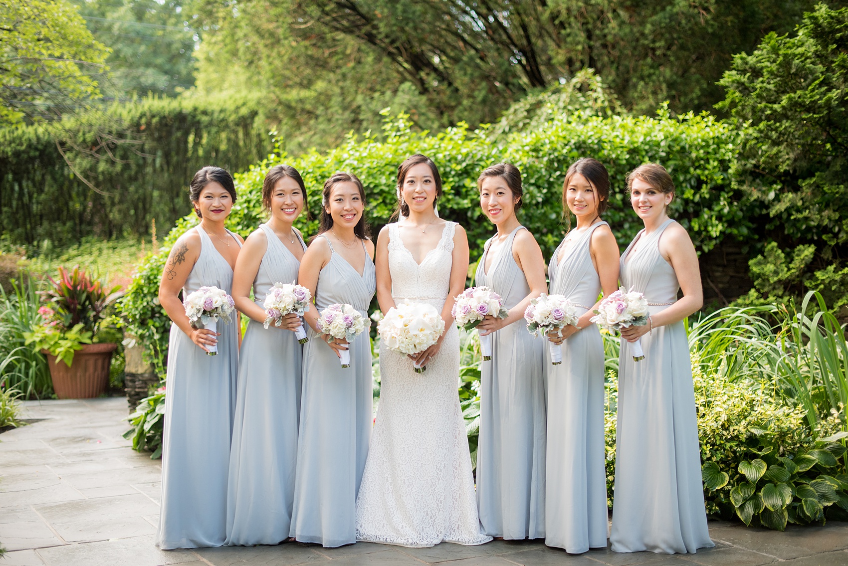 Mikkel Paige Photography pictures of a Westbury Manor wedding on Long Island. Photo of the bridal party in blue-grey gowns.