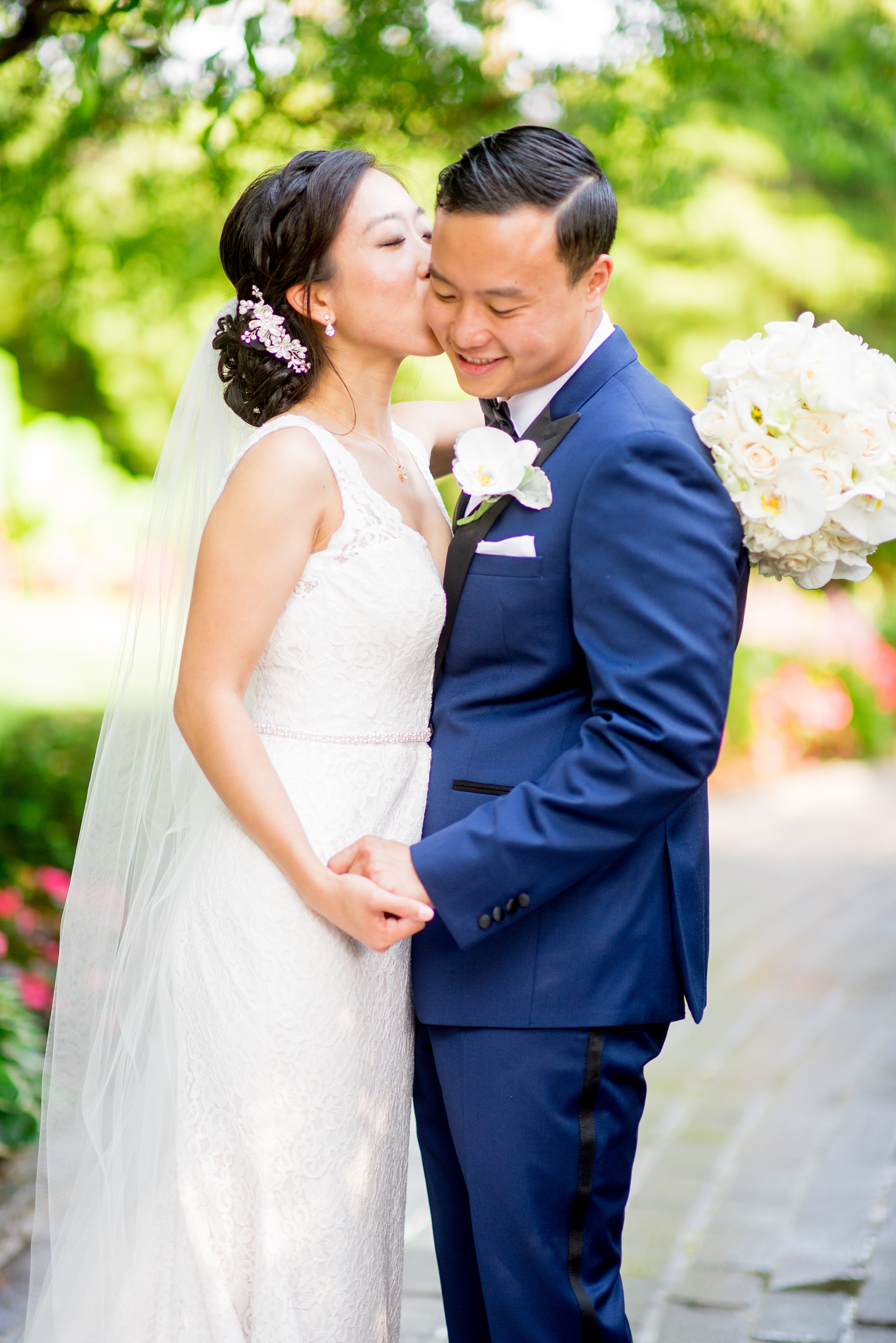 Mikkel Paige Photography pictures of a Westbury Manor wedding on Long Island. Photo of the bride kissing the groom in the garden.