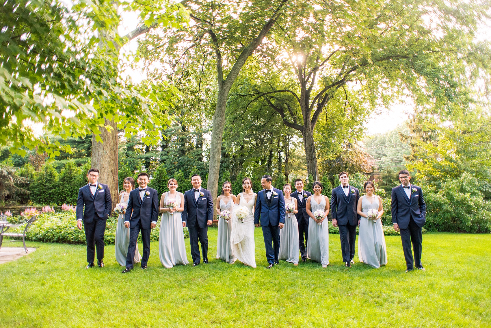 Mikkel Paige Photography pictures of a Westbury Manor wedding on Long Island. Photo of the bridal party in blue-grey gowns and groomsmen in navy.