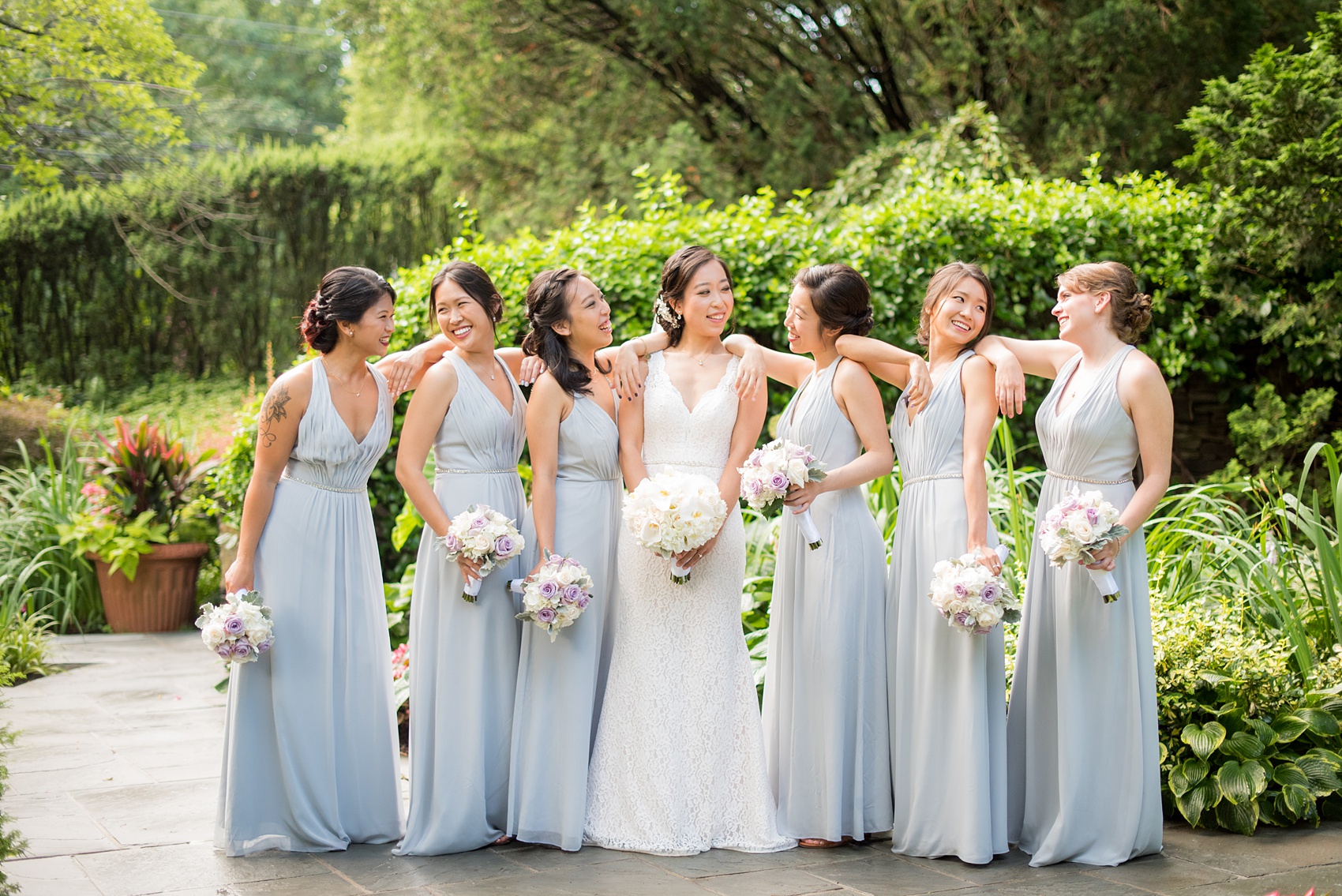 Mikkel Paige Photography pictures of a Westbury Manor wedding on Long Island. Casual photo of the bridesmaids in blue-grey gowns.