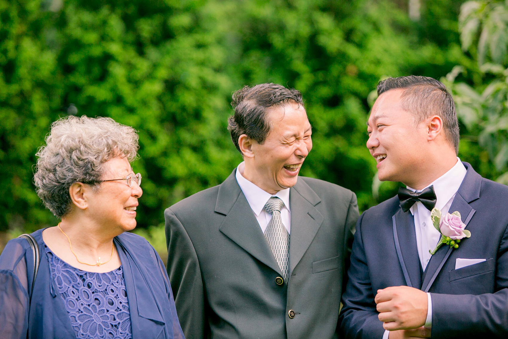 Mikkel Paige Photography pictures of a Westbury Manor wedding on Long Island. An candid photo of the family in the garden.