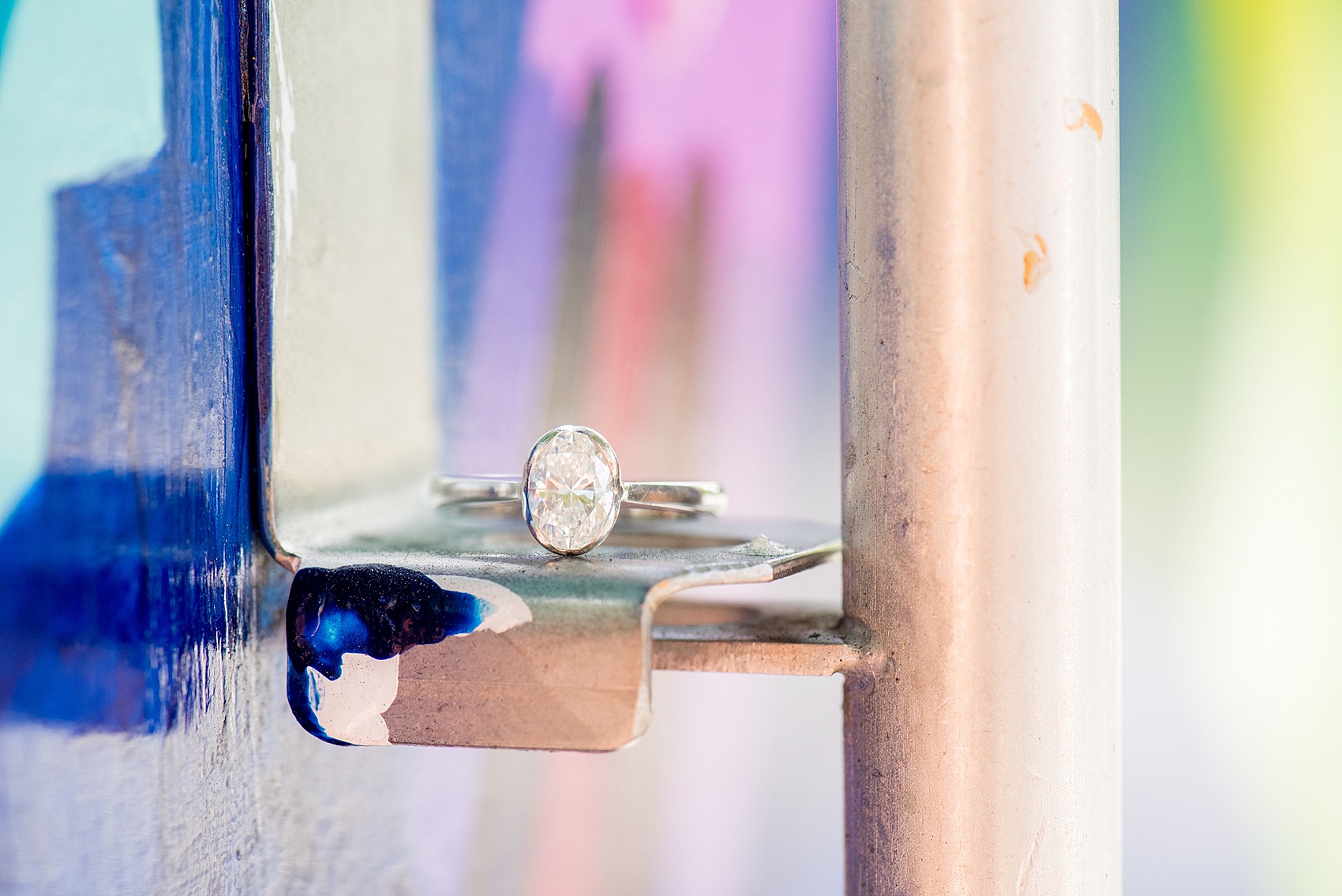 Mikkel Paige Photography pictures of a colorful engagement session in Chapel Hill North Carolina. Photo of the bride's oval diamond engagement ring in a modern setting.