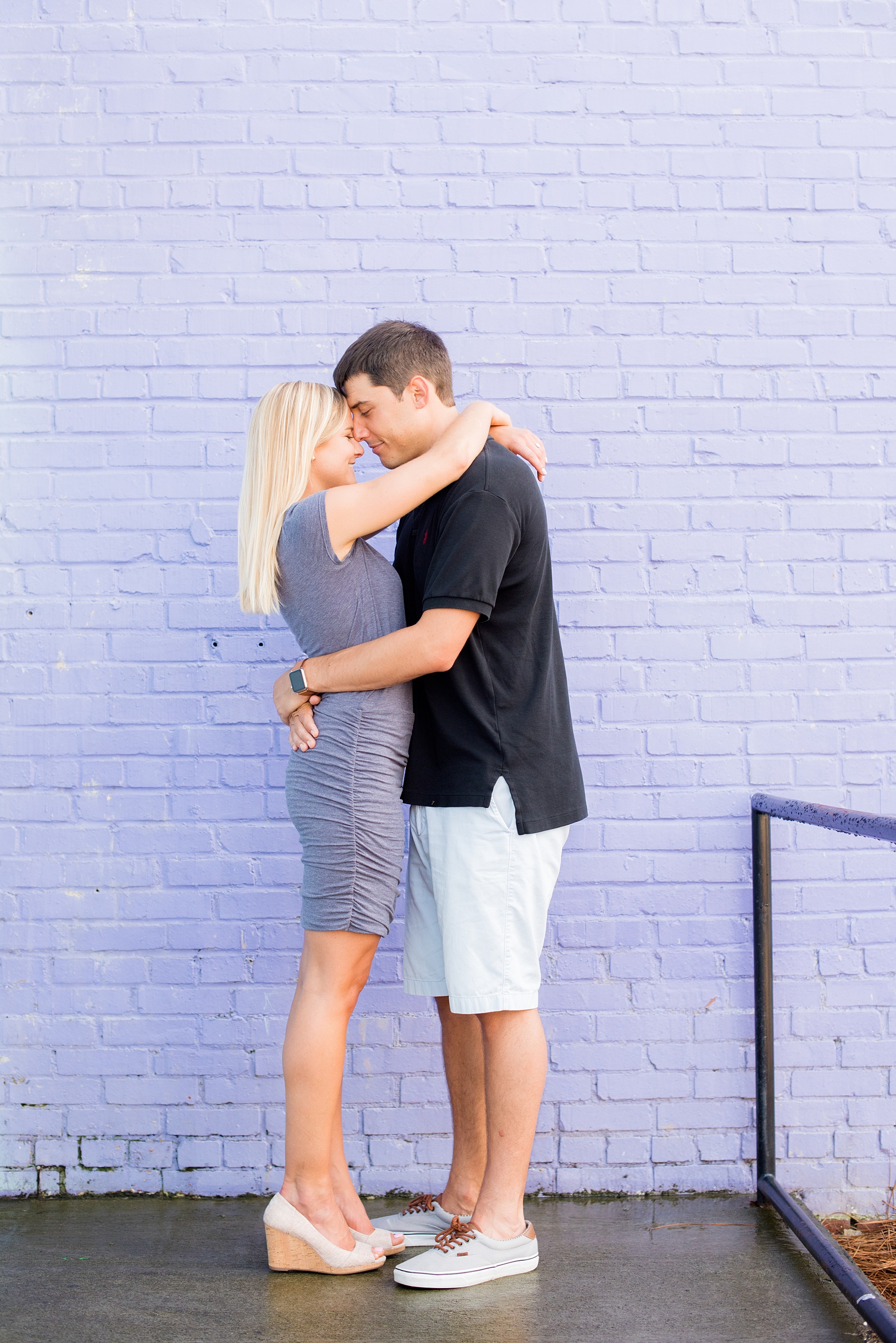 Mikkel Paige Photography pictures of a colorful engagement session in Chapel Hill North Carolina. The bride and groom hug in front of purple and light blue walls.