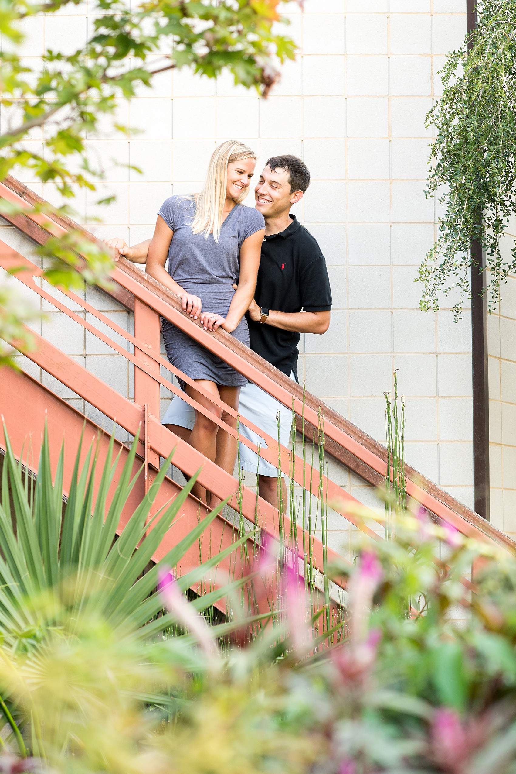 Mikkel Paige Photography pictures of a colorful engagement session in Chapel Hill North Carolina. The bride and groom smile on a landscaped staircase.