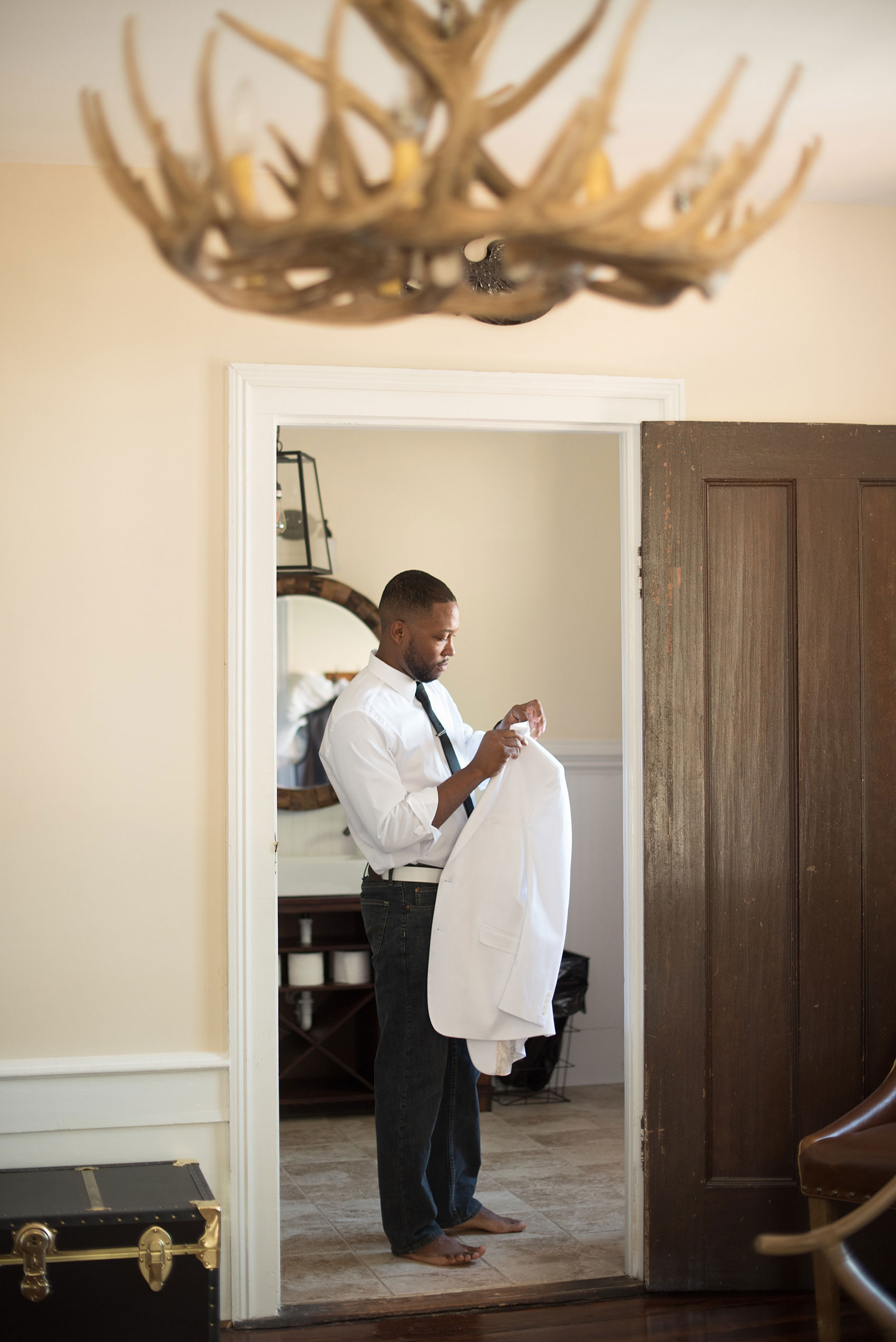 Mikkel Paige Photography pictures of a wedding at Leslie-Alford Mim's House in North Carolina for a Mad Dash Weddings event. Photo of the groom getting ready in the masculine groom's suite.