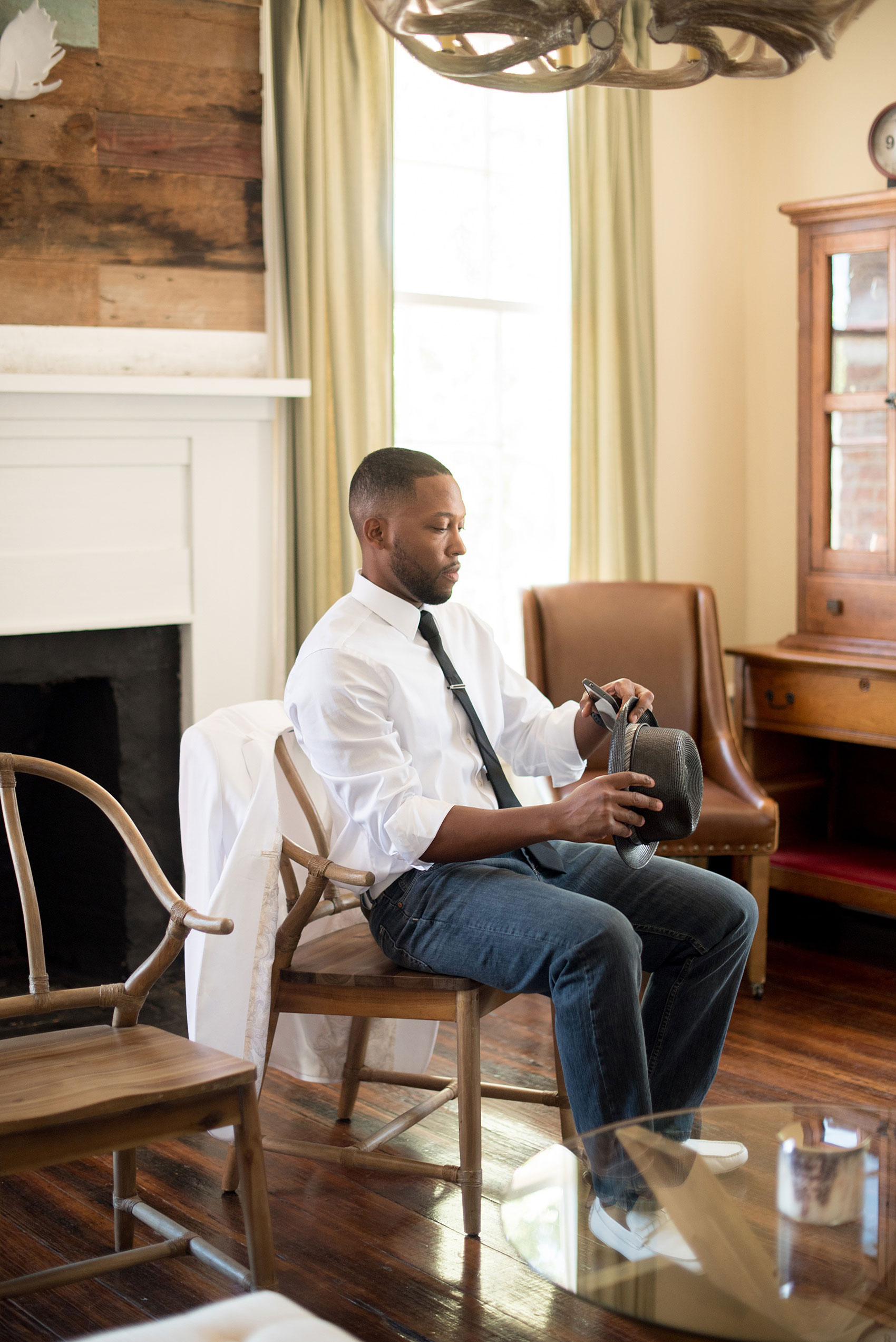 Mikkel Paige Photography pictures of a wedding at Leslie-Alford Mim's House in North Carolina for a Mad Dash Weddings event. Photo of the groom getting ready in the masculine groom's suite.