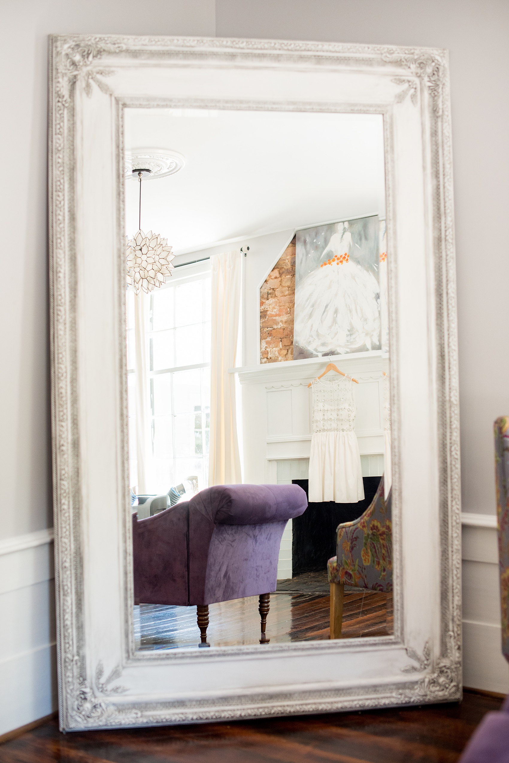 Mikkel Paige Photography pictures of a wedding at Leslie-Alford Mim's House in North Carolina for a Mad Dash Weddings event. Photo of the bride's short dress hanging in the feminine bridal suite.