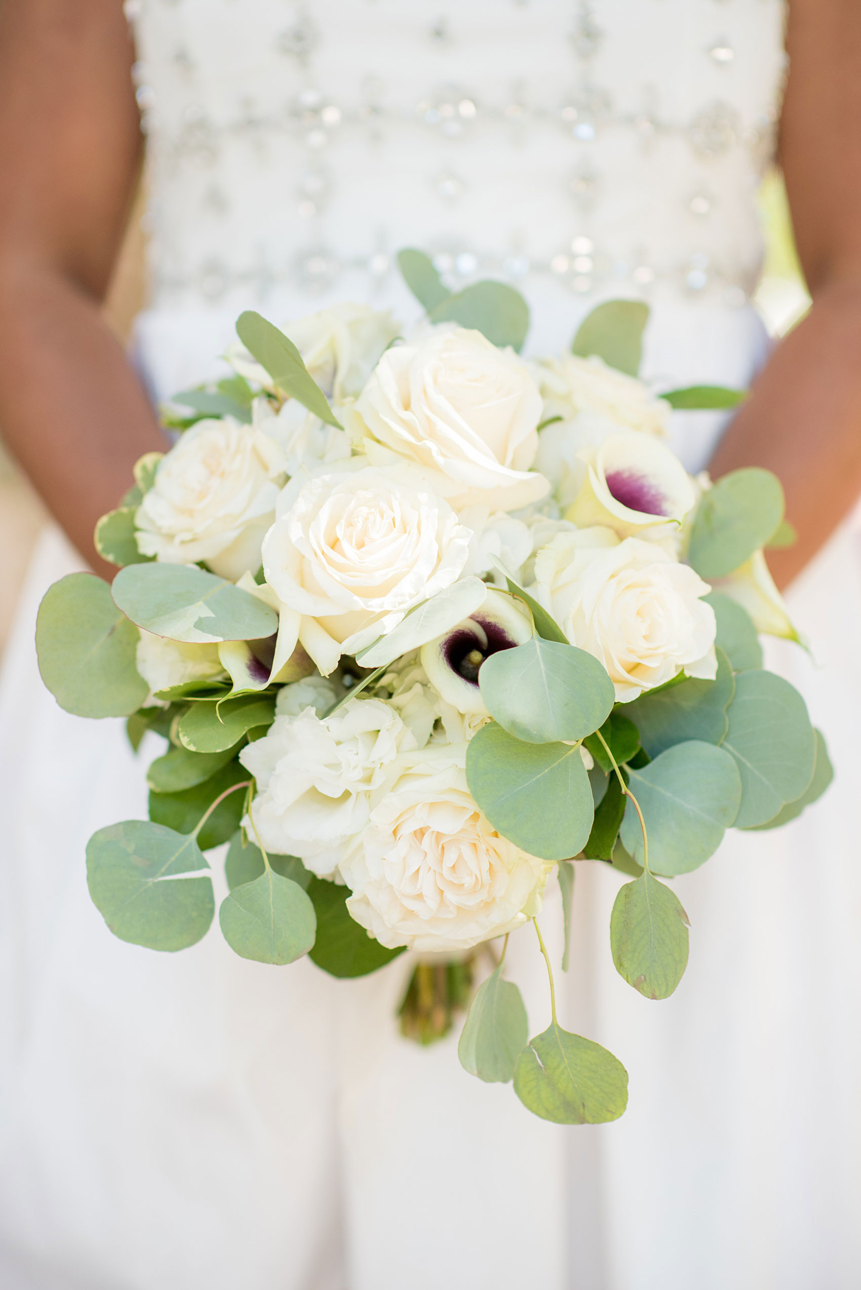 Mikkel Paige Photography pictures of a wedding at Leslie-Alford Mim's House in North Carolina for a Mad Dash Weddings event. Photo of the bride's white rose, Picasso Calla Lily and silver dollar eucalyptus greenery.