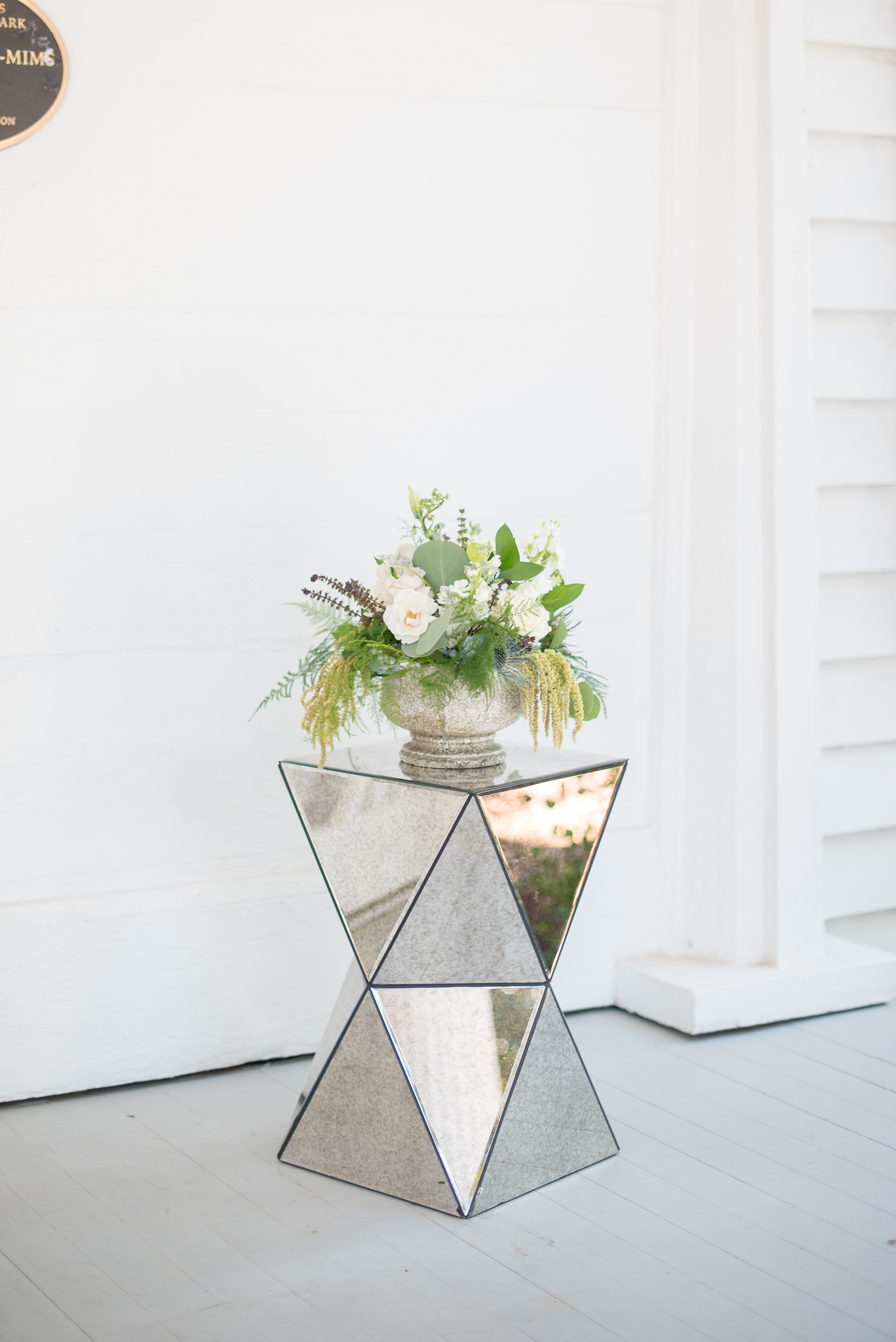 Mikkel Paige Photography pictures of a wedding at Leslie-Alford Mim's House in North Carolina for a Mad Dash Weddings event. Photo of a trendy, angled mirror side table and floral centerpiece.