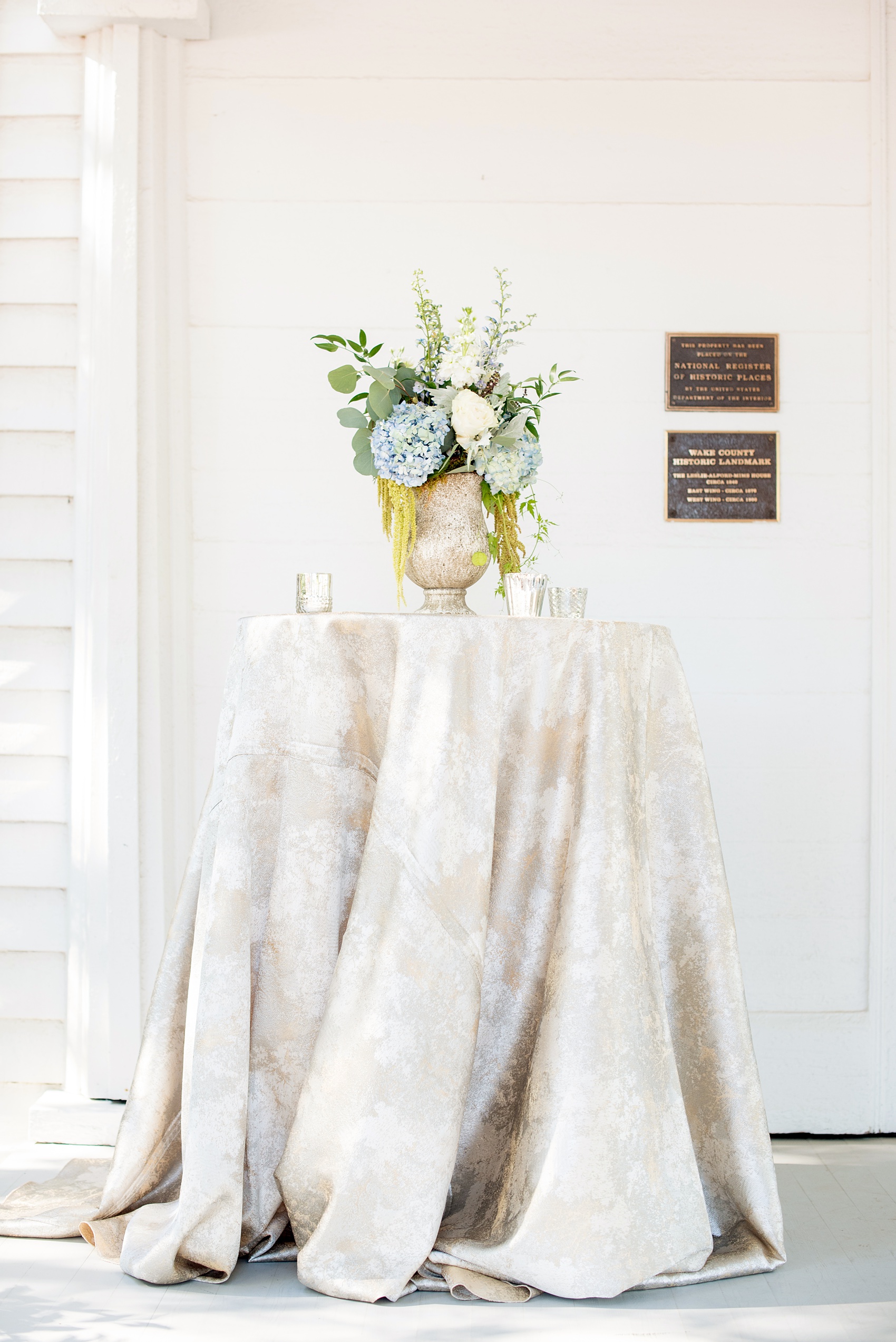 Mikkel Paige Photography pictures of a wedding at Leslie-Alford Mim's House in North Carolina for a Mad Dash Weddings event. Photo of a metallic cocktail table and summer floral arrangement.