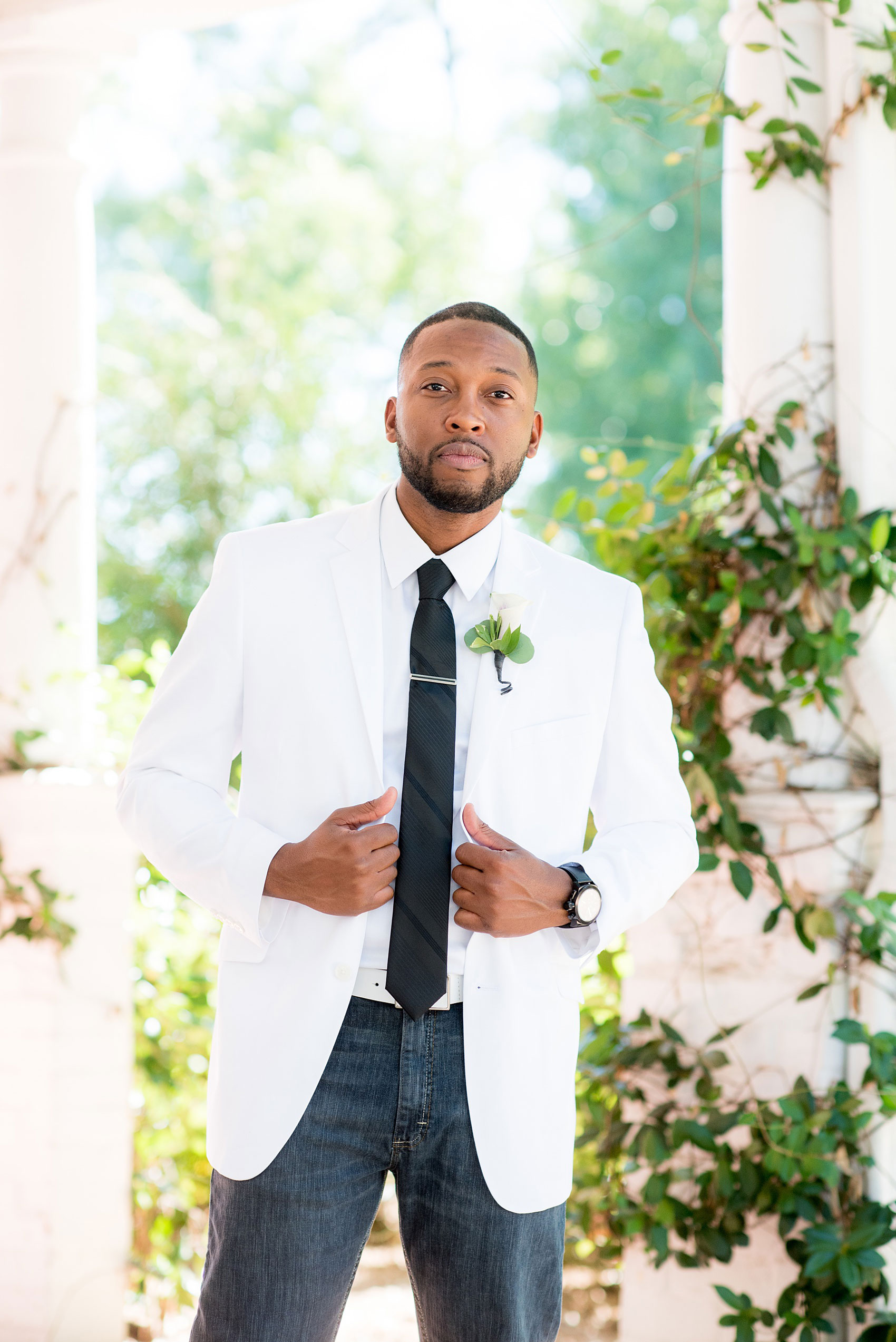 Mikkel Paige Photography pictures of a wedding at Leslie-Alford Mim's House in North Carolina for a Mad Dash Weddings event. Photo of the groom in white coat, black tie, and casual dark jeans.