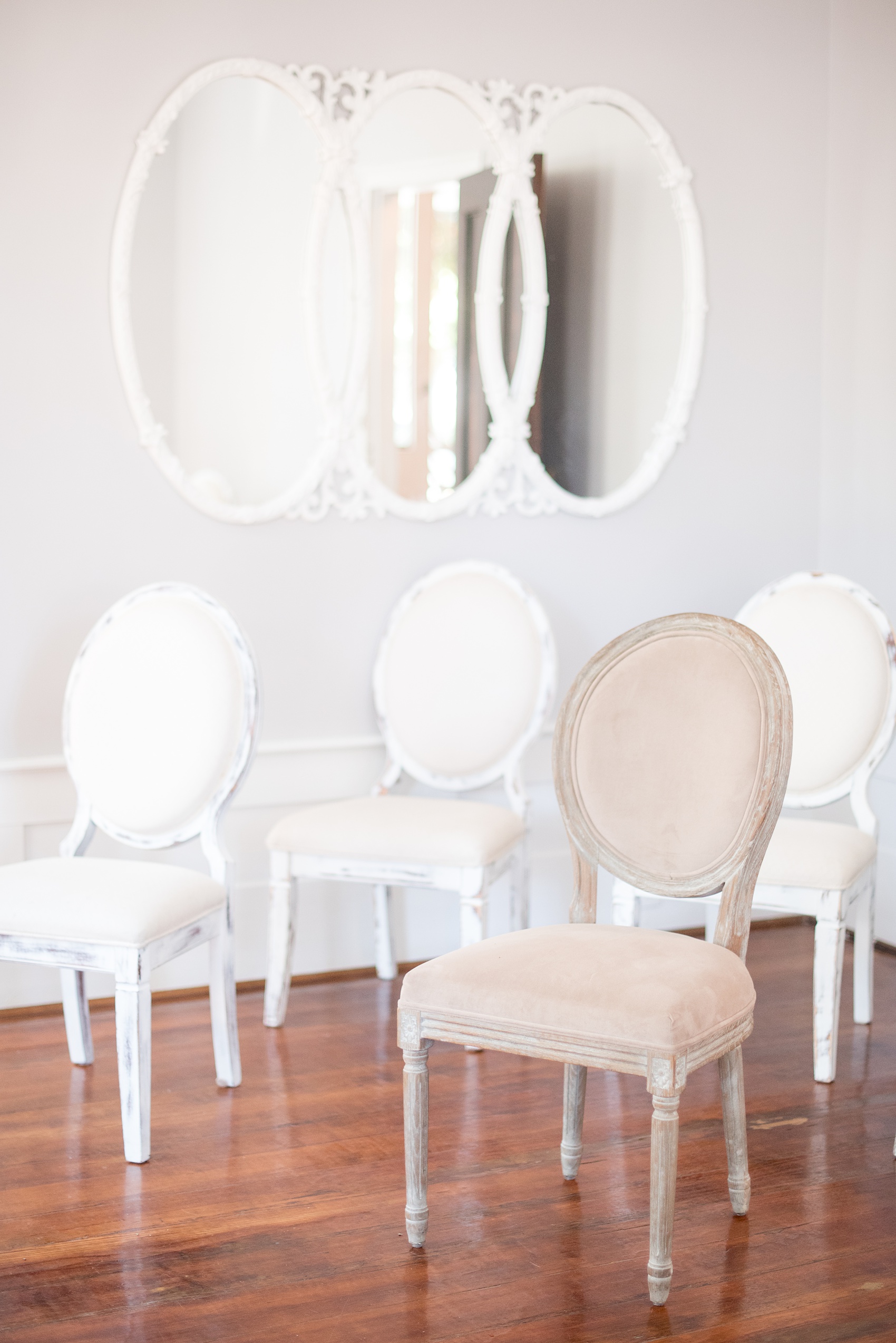 Mikkel Paige Photography pictures of a wedding at Leslie-Alford Mim's House in North Carolina for a Mad Dash Weddings event. Photo of decorative white cushioned chairs for an elopement inside the historic home.