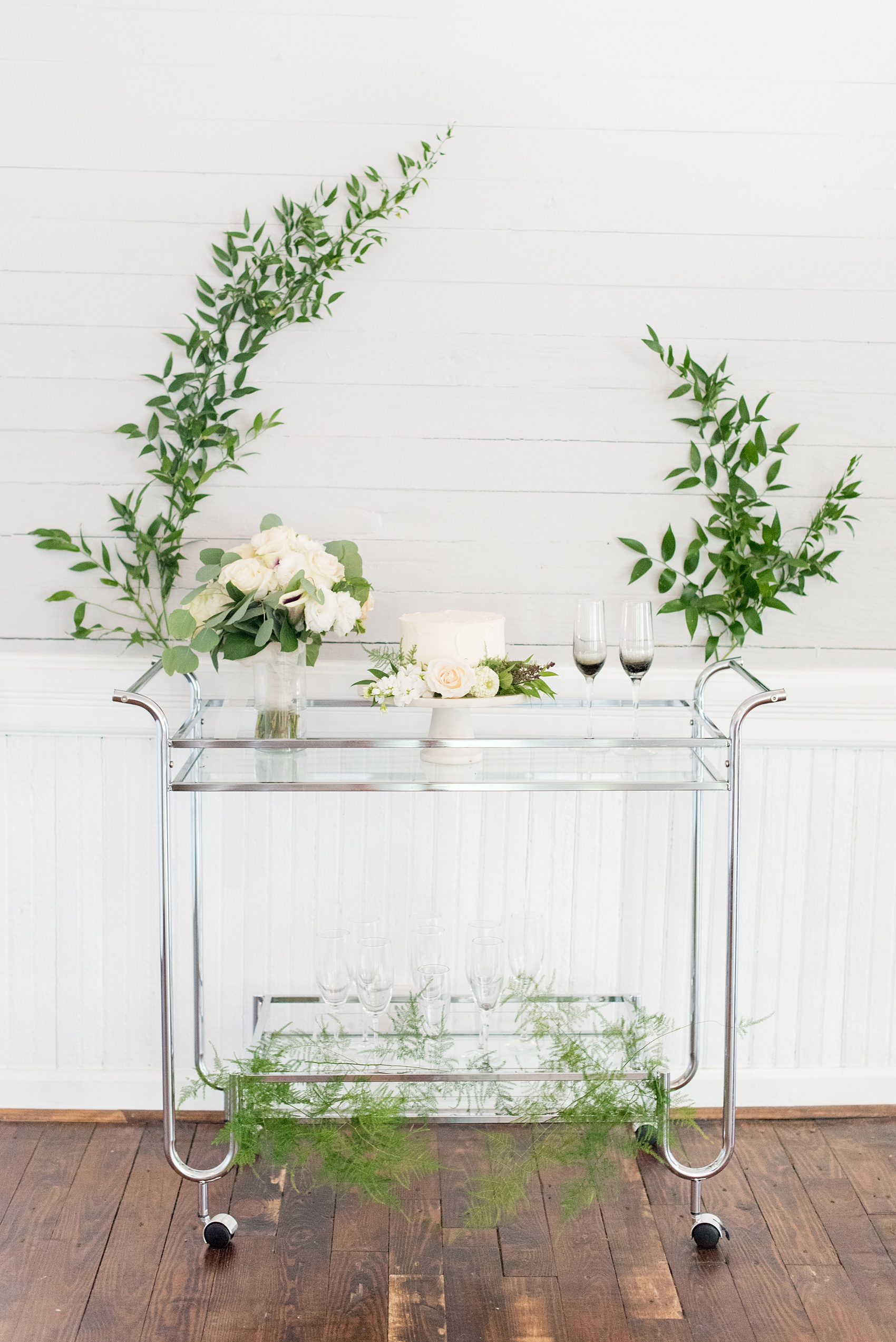 Mikkel Paige Photography pictures of a wedding at Leslie-Alford Mim's House in North Carolina for a Mad Dash Weddings event. Photo of the couple's cake cart with black and grey ombre champagne flutes.