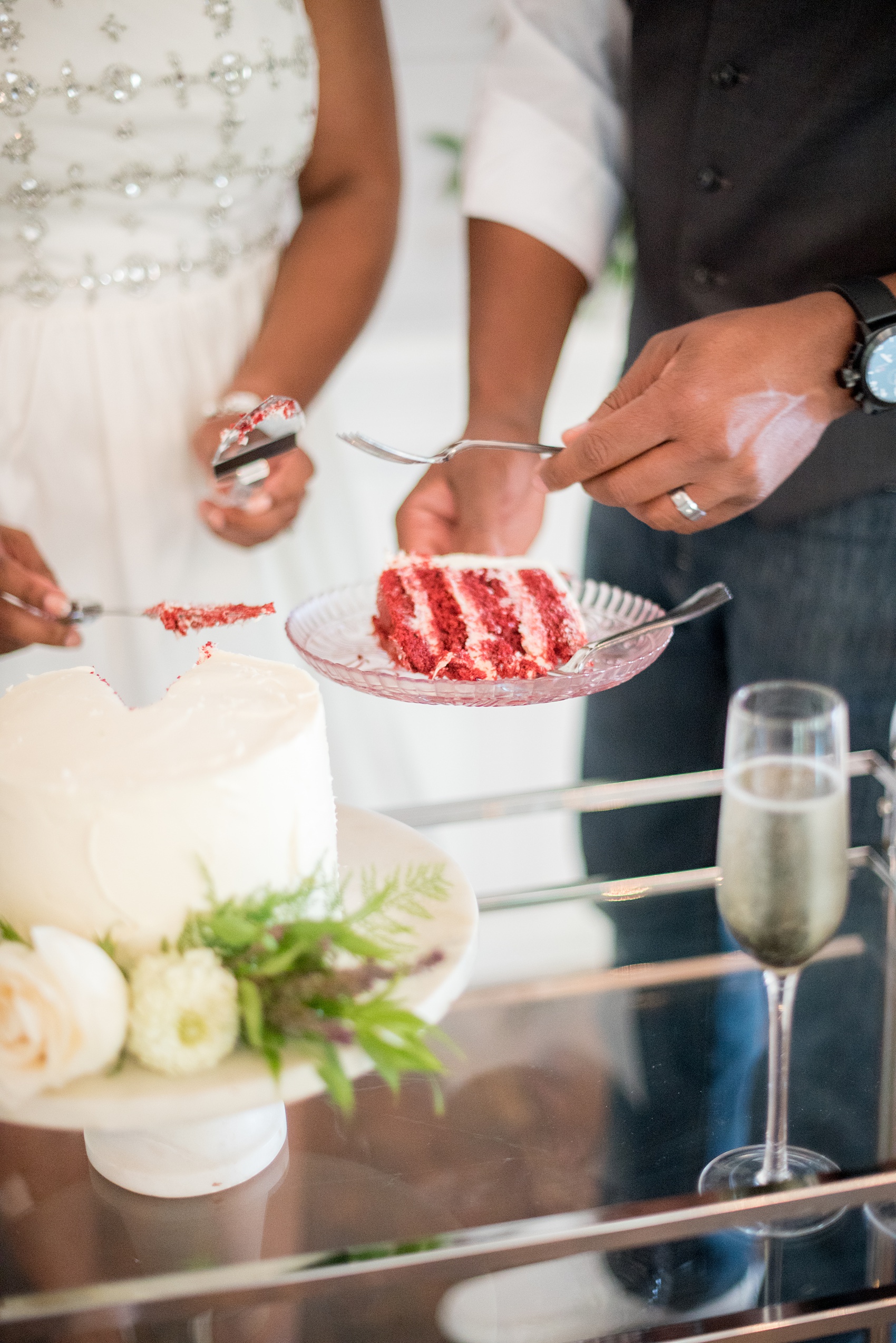 Mikkel Paige Photography pictures of a wedding at Leslie-Alford Mim's House in North Carolina for a Mad Dash Weddings event. Photo of the petite red-velvet, white frosted wedding cake adorned with flowers. 