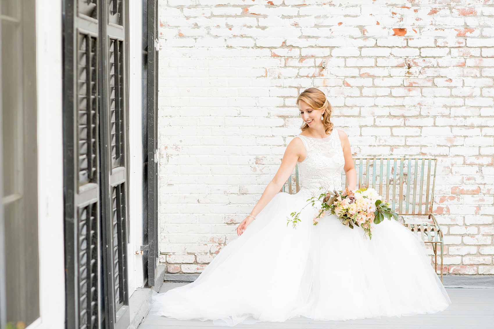 Mikkel Paige Photography photos from a Southwood Estate Wedding in Germantown, New York in the Hudson Valley. Picture of the bride on the front porch against white bricks.