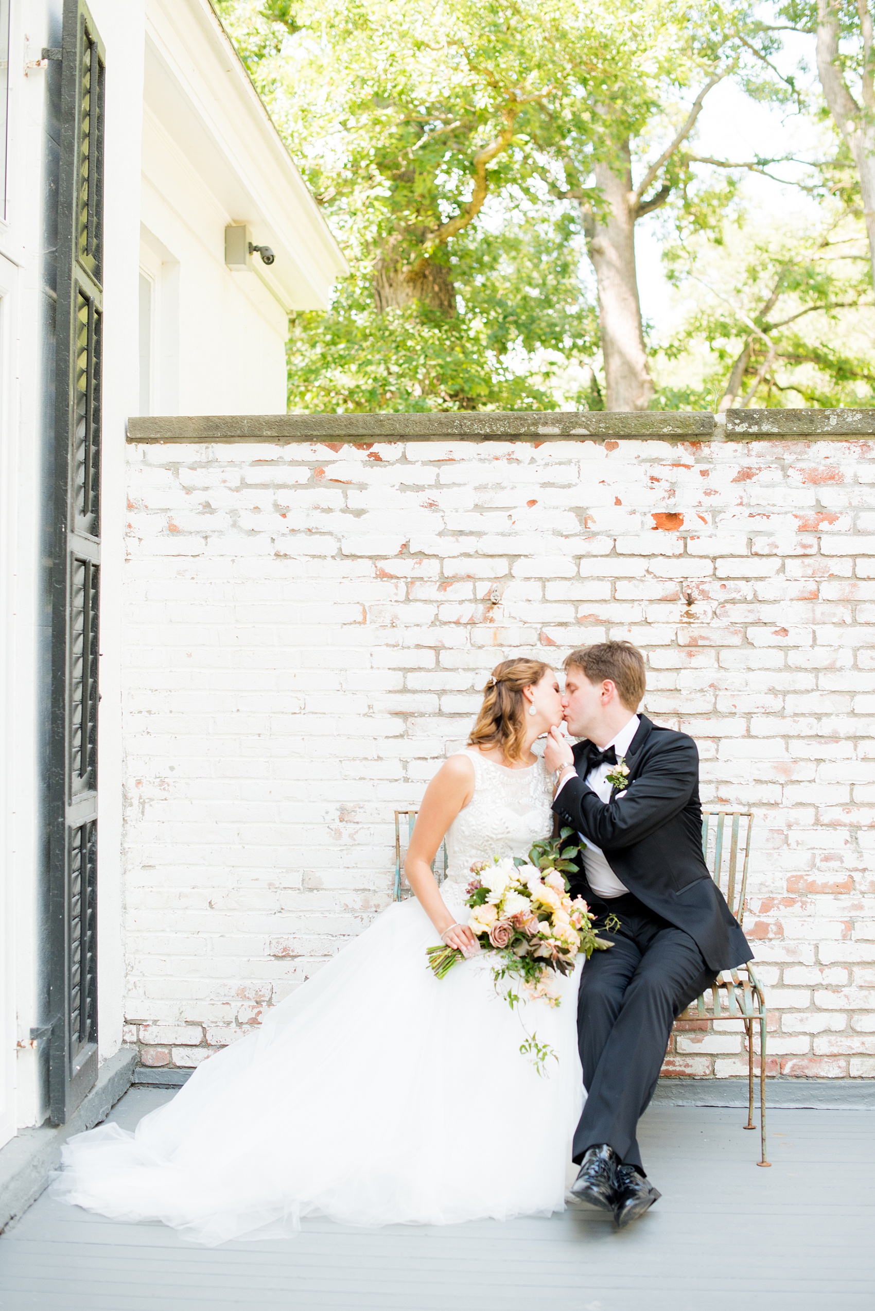 Mikkel Paige Photography photos from a Southwood Estate Wedding in Germantown, New York in the Hudson Valley. Picture of the bride and groom on the front porch against white bricks.