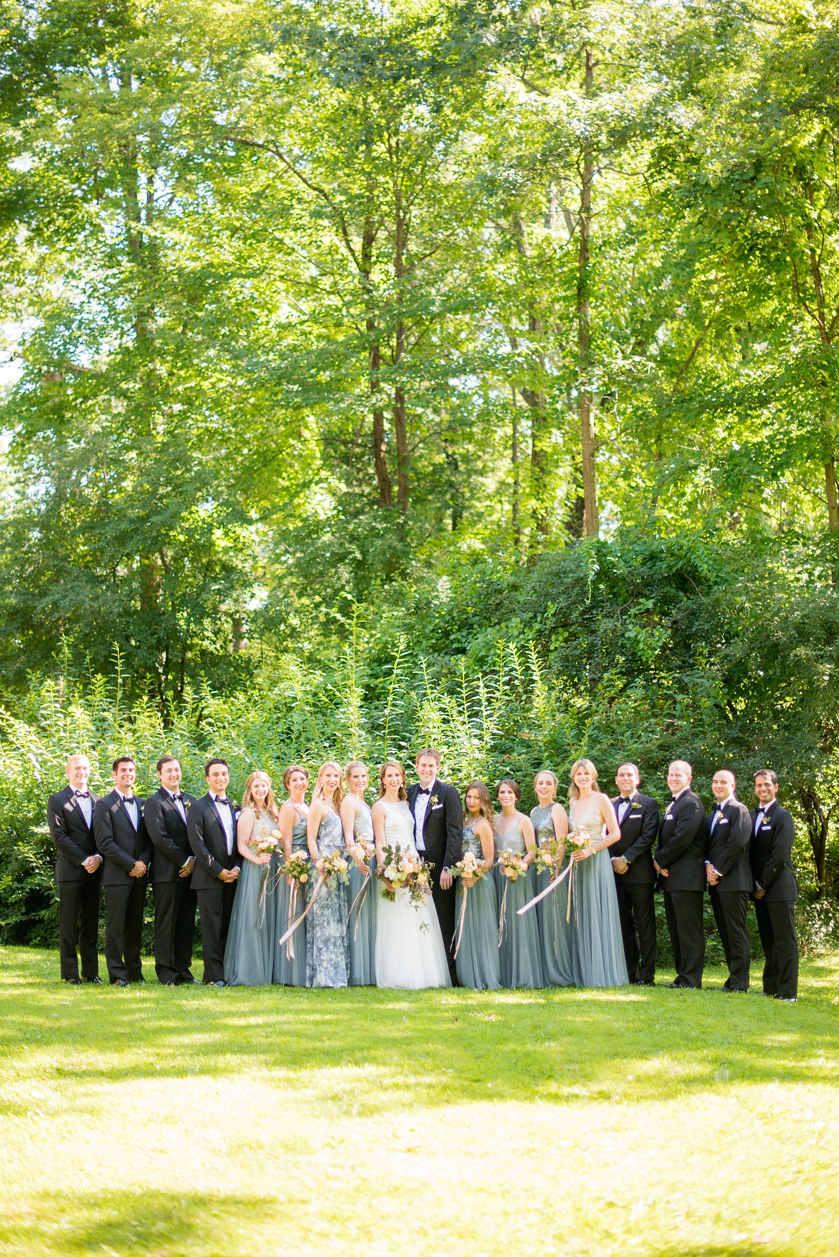 Mikkel Paige Photography photos from a Southwood Estate Wedding in Germantown, New York in the Hudson Valley. Picture of the bride and her bridal party in cornflower blue skirts with mismatched tops and the groomsmen in classic black tuxedos and bow ties.