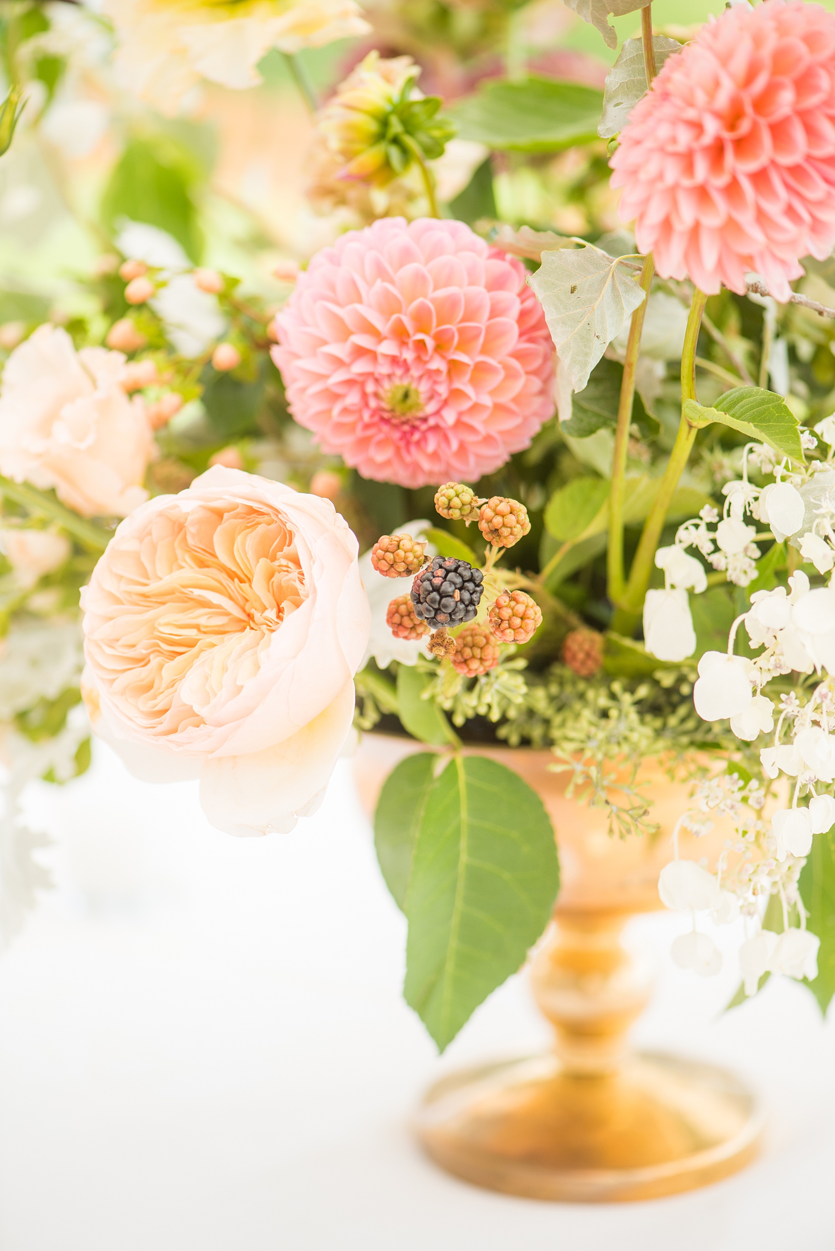 Mikkel Paige Photography photos from a Southwood Estate Wedding in Germantown, New York in the Hudson Valley. Picture of the floral centerpiece on a table with flowers including mauve, dusty rose, burgundy, lavender, pink roses, dahlias, spray roses, peaches and berries.