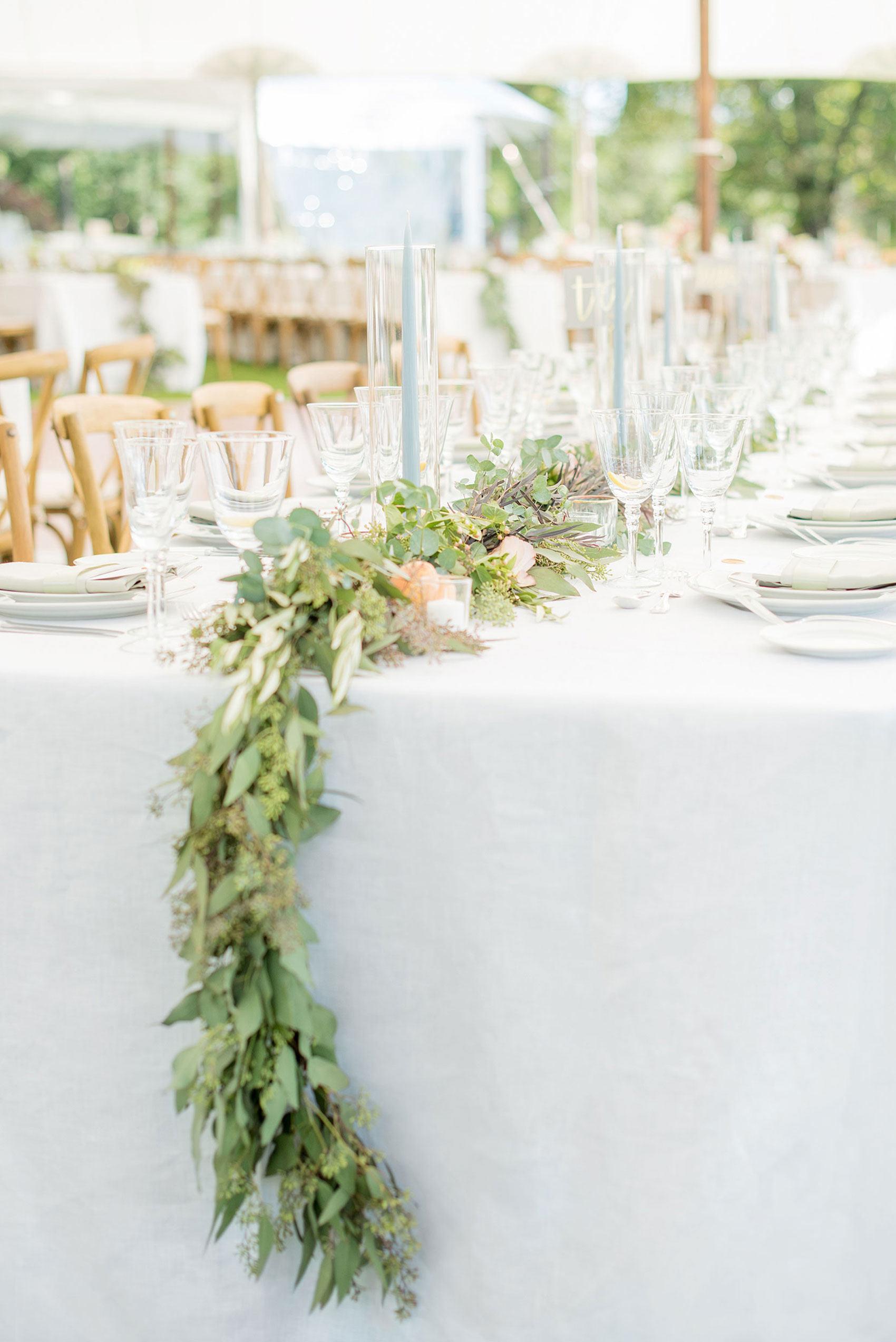 Mikkel Paige Photography photos from a Southwood Estate Wedding in Germantown, New York in the Hudson Valley. Picture of the eucalyptus garland, roses, peaches and blue tapered candles completed the tables.