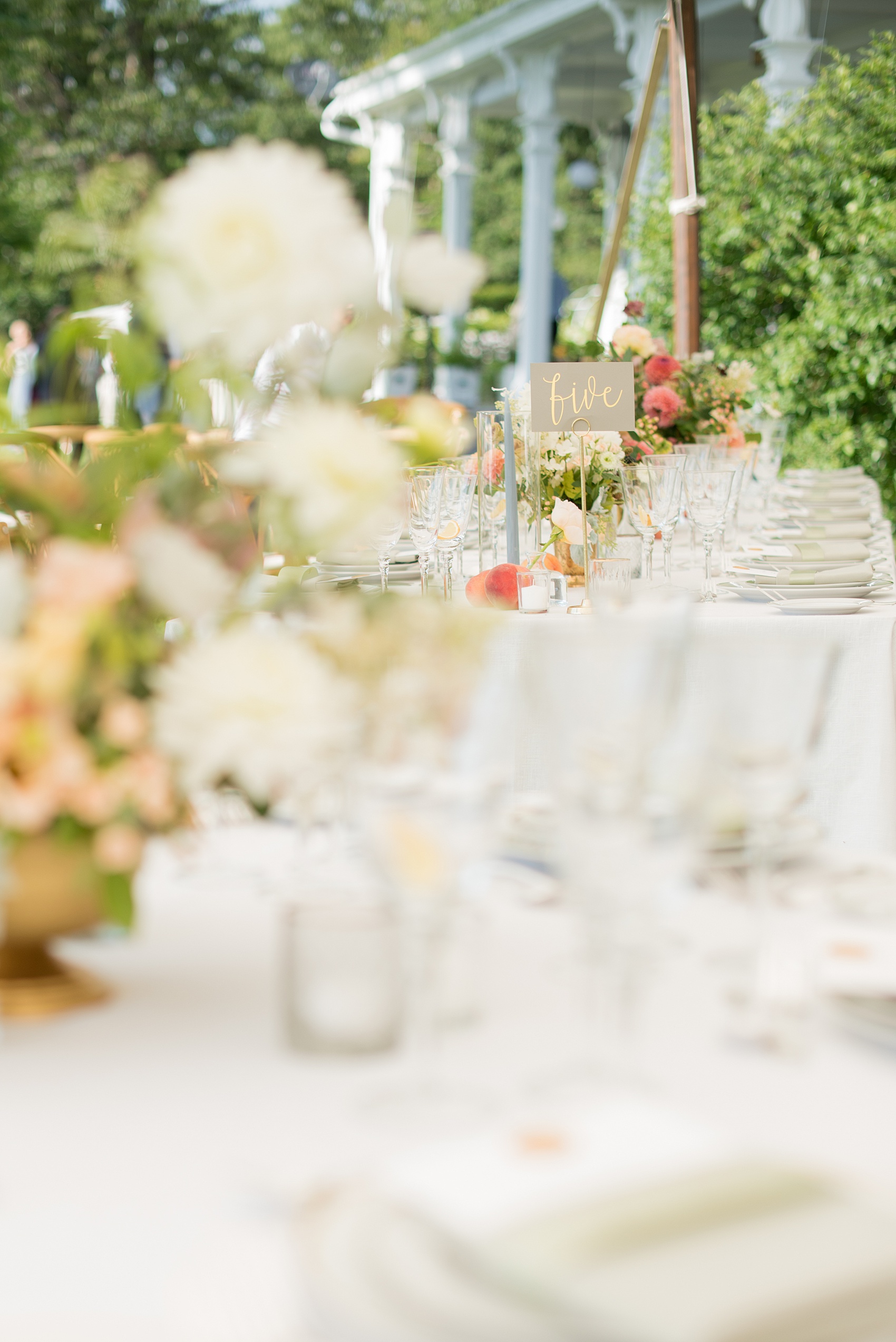 Mikkel Paige Photography photos from a Southwood Estate Wedding in Germantown, New York in the Hudson Valley. Picture of the tables with blue candles, colorful flowers and peach fruit accents.