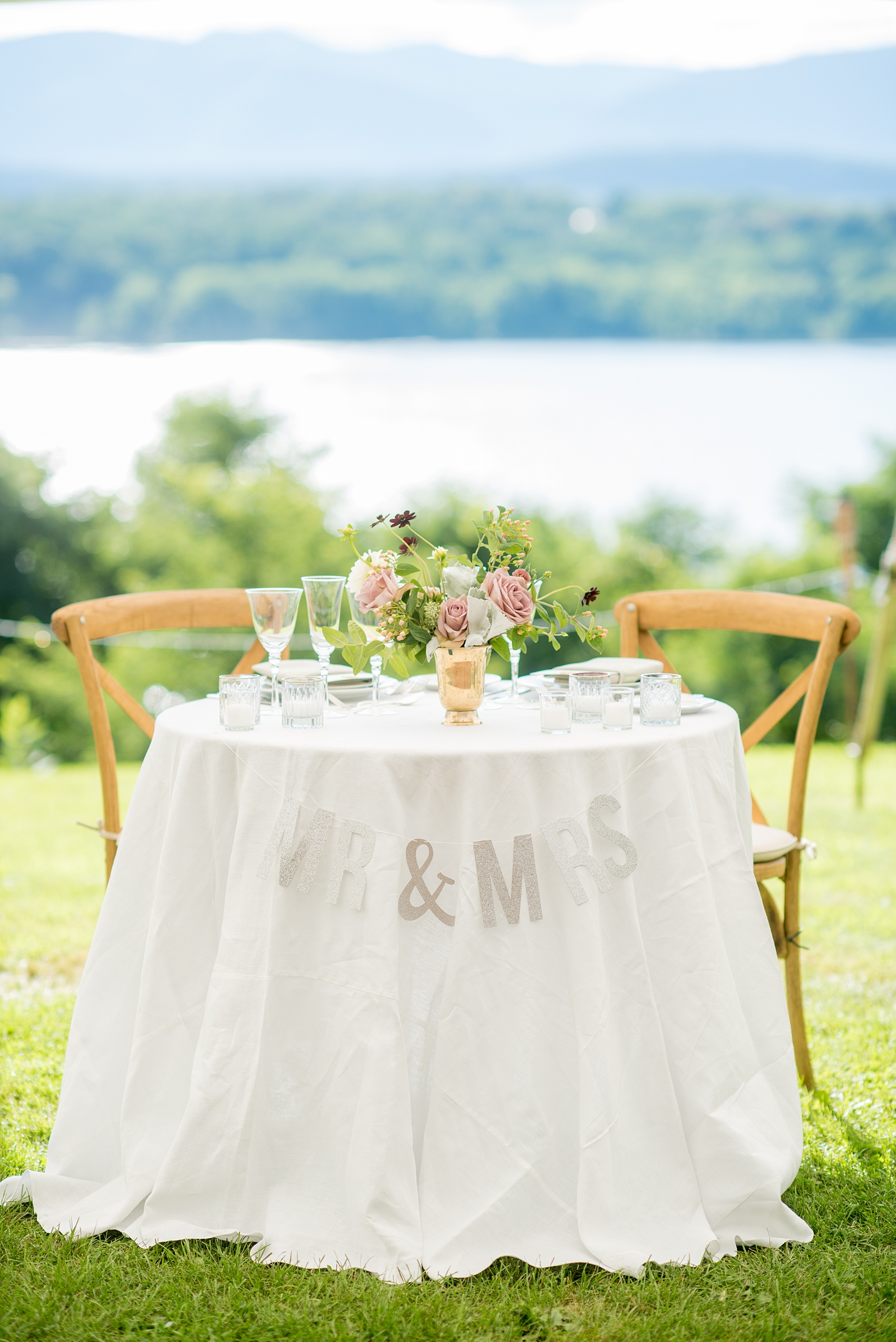 Mikkel Paige Photography photos from a Southwood Estate Wedding in Germantown, New York in the Hudson Valley. Picture of the round sweetheart table with floral centerpiece and silver glitter Mr. and Mrs. sign.