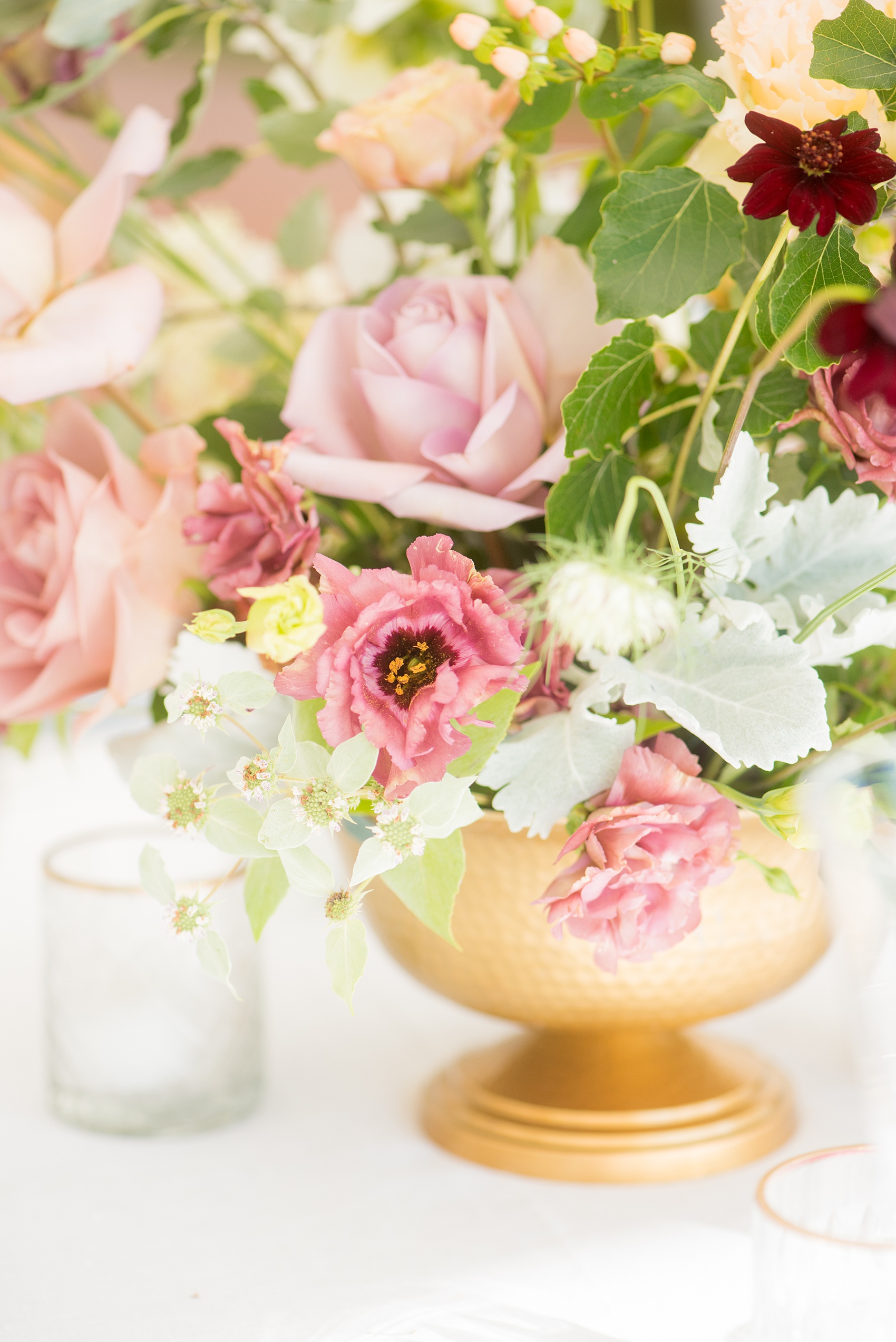 Mikkel Paige Photography photos from a Southwood Estate Wedding in Germantown, New York in the Hudson Valley. Picture of the floral centerpiece on a table with flowers including mauve, dusty rose, burgundy, lavender, pink roses, dahlias, spray roses, peaches and berries.