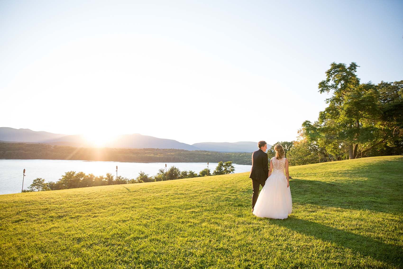 Mikkel Paige Photography photos from a Southwood Estate Wedding in Germantown, New York in the Hudson Valley. Golden hour photo of the bride and groom walking towards the picturesque mountains.