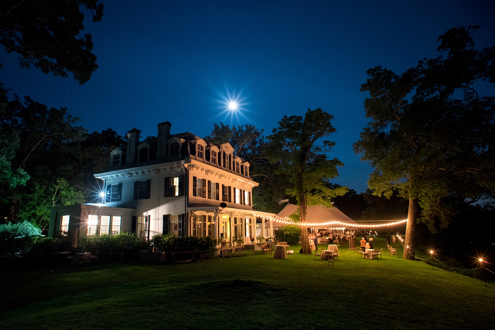 Mikkel Paige Photography photos from a Southwood Estate Wedding in Germantown, New York in the Hudson Valley. Picture of the venue at night with the moon, stars and string lights.