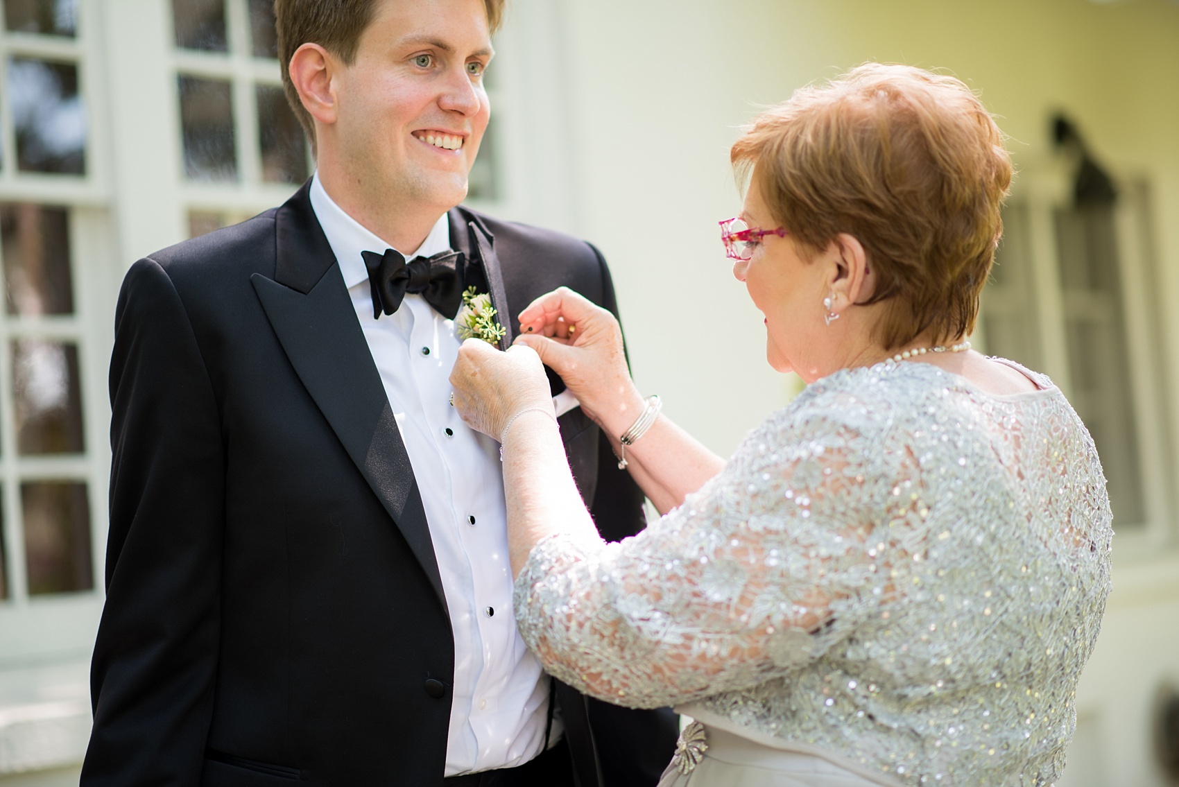 Mikkel Paige Photography photos from a Southwood Estate Wedding in Germantown, New York in the Hudson Valley. A picture of the mother of the groom pinning on his boutonniere.