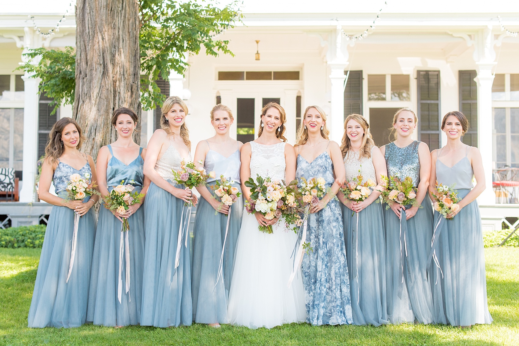 Mikkel Paige Photography photos from a wedding at Southwood Estate in Germantown, New York. Picture of the bride with her bridal party in mismatched blue gowns.